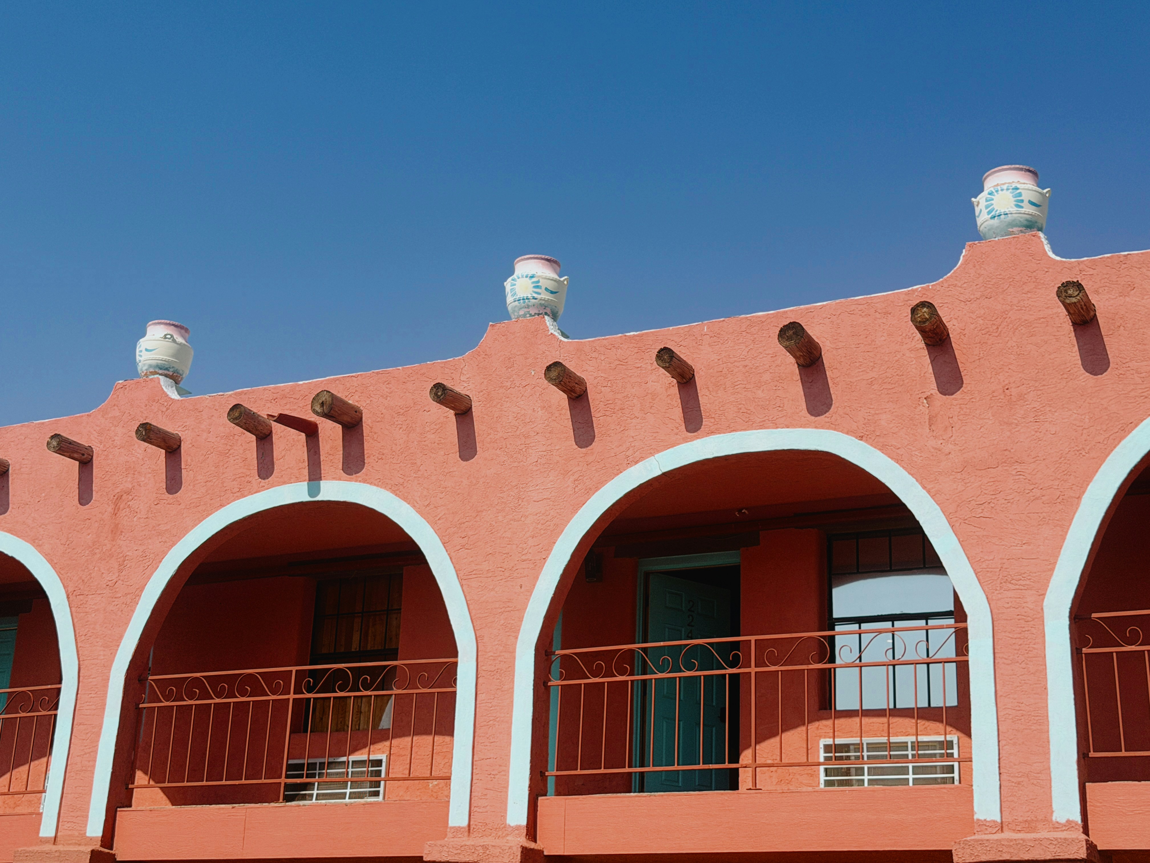 Terracotta building with arched balconies against a vivid blue sky
