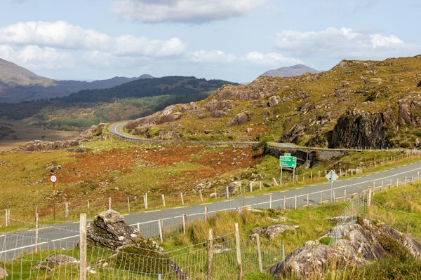 A winding road through a rocky, green landscape in Killarney, Ireland