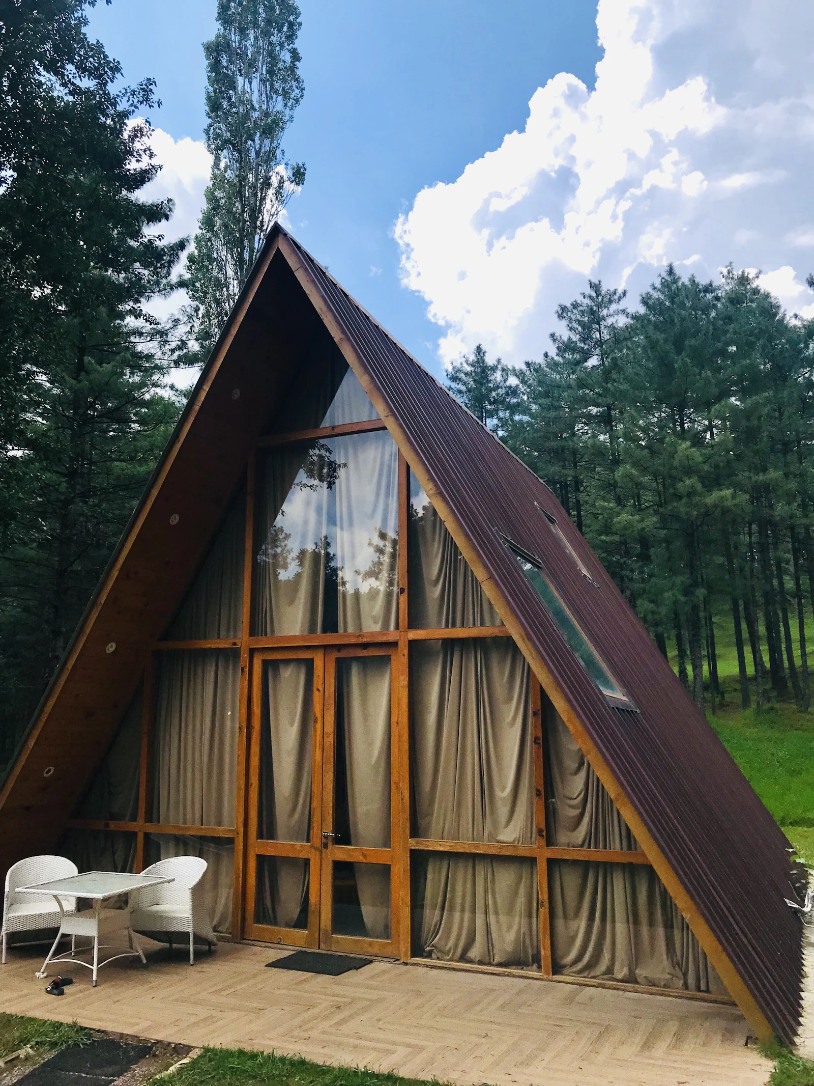 Современный коттедж A-frame среди сосен