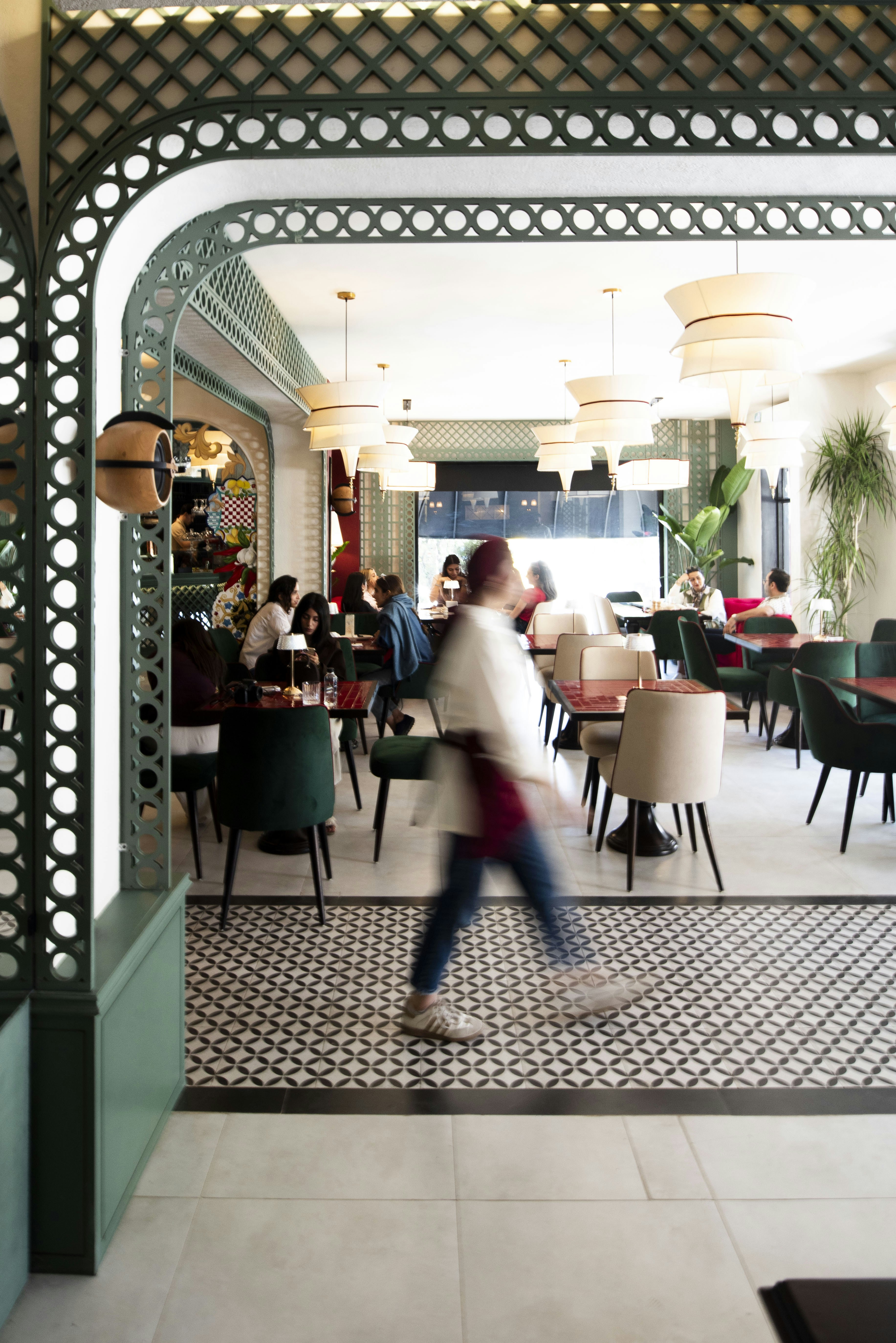 Elegante ristorante con clienti e un cameriere sfocato in movimento.