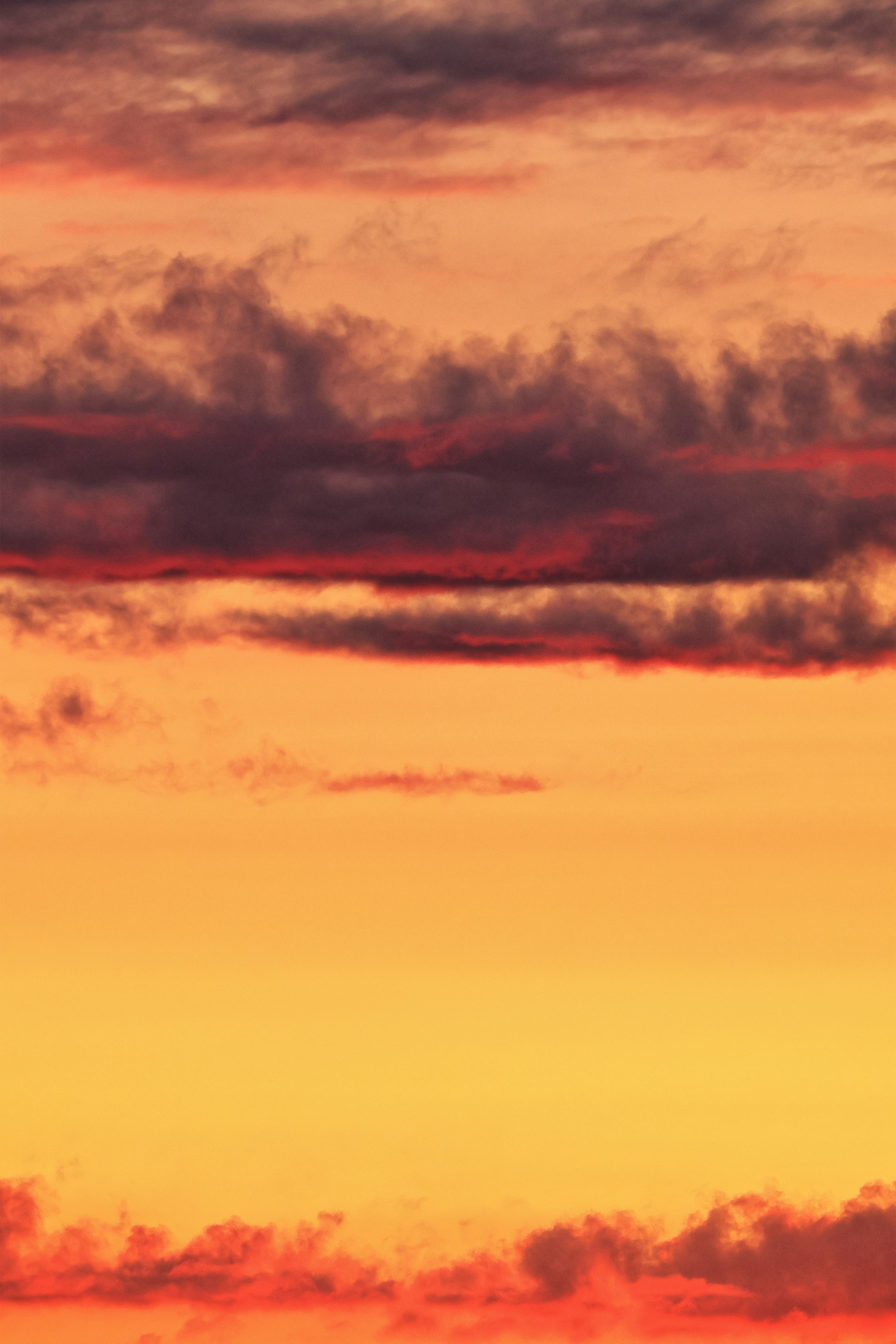 Vibrant sunset sky with orange, yellow, and dark red clouds.