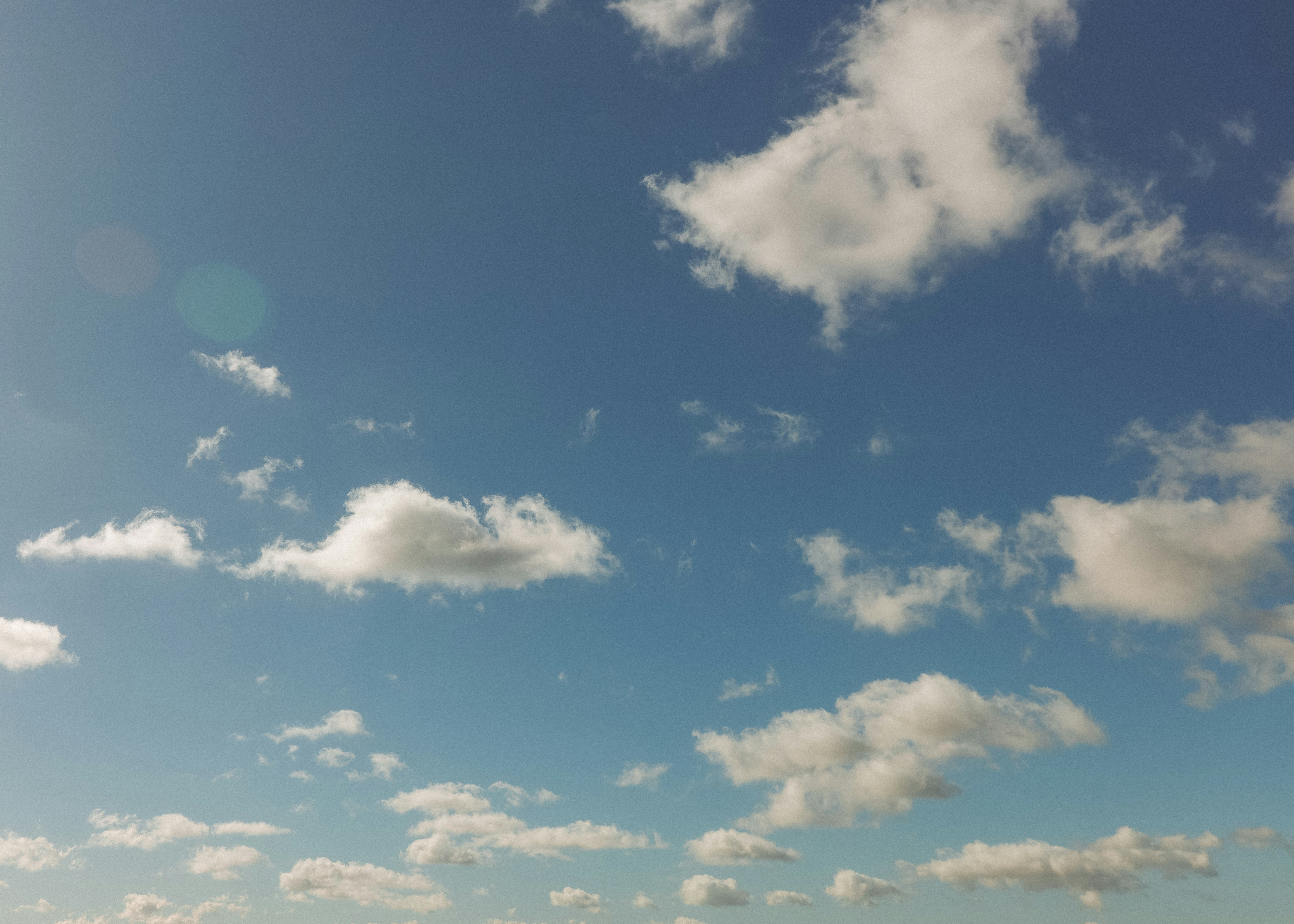 Cielo azul con nubes blancas dispersas en un día soleado.