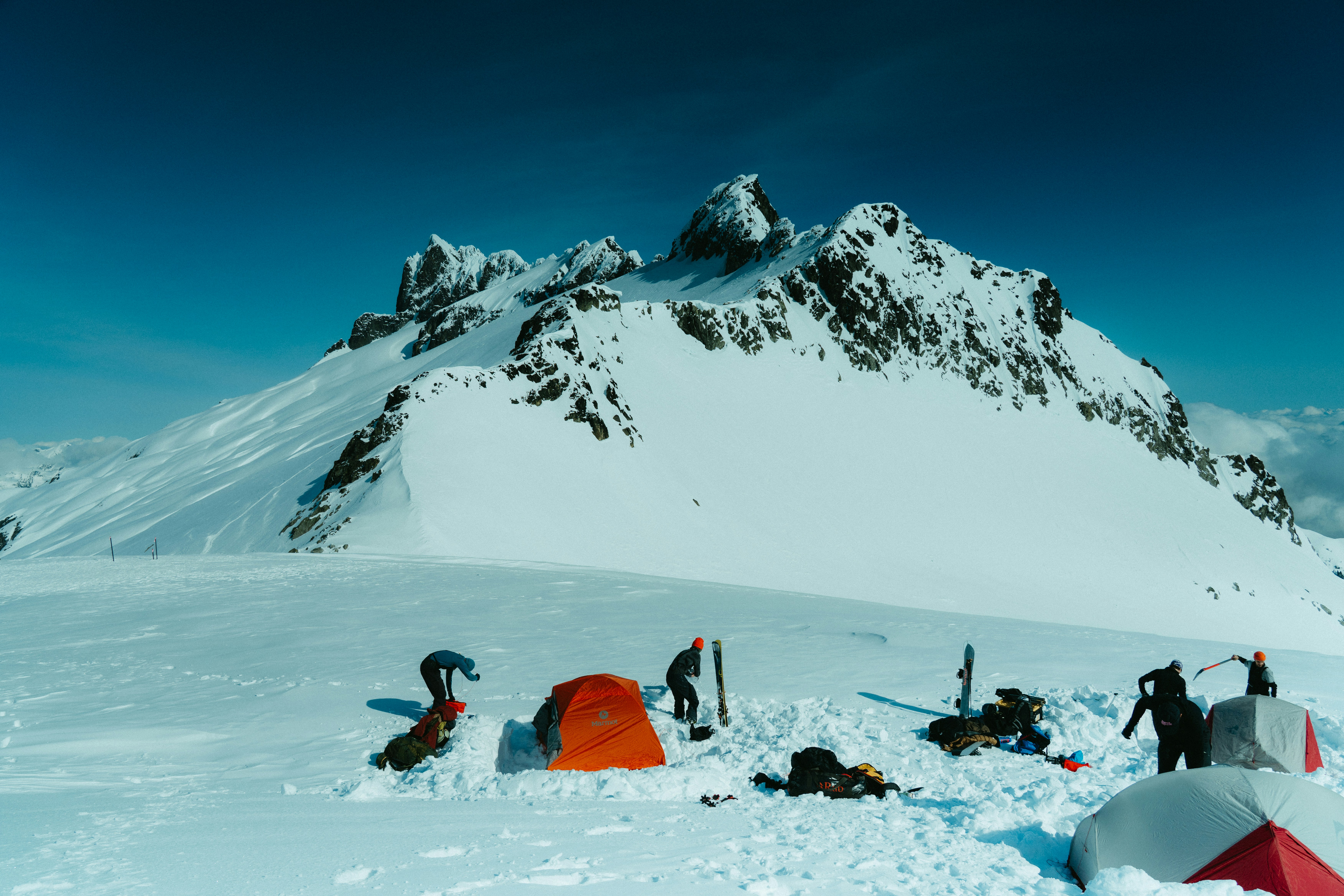 Skiers camping with tents on a vast snowy mountain