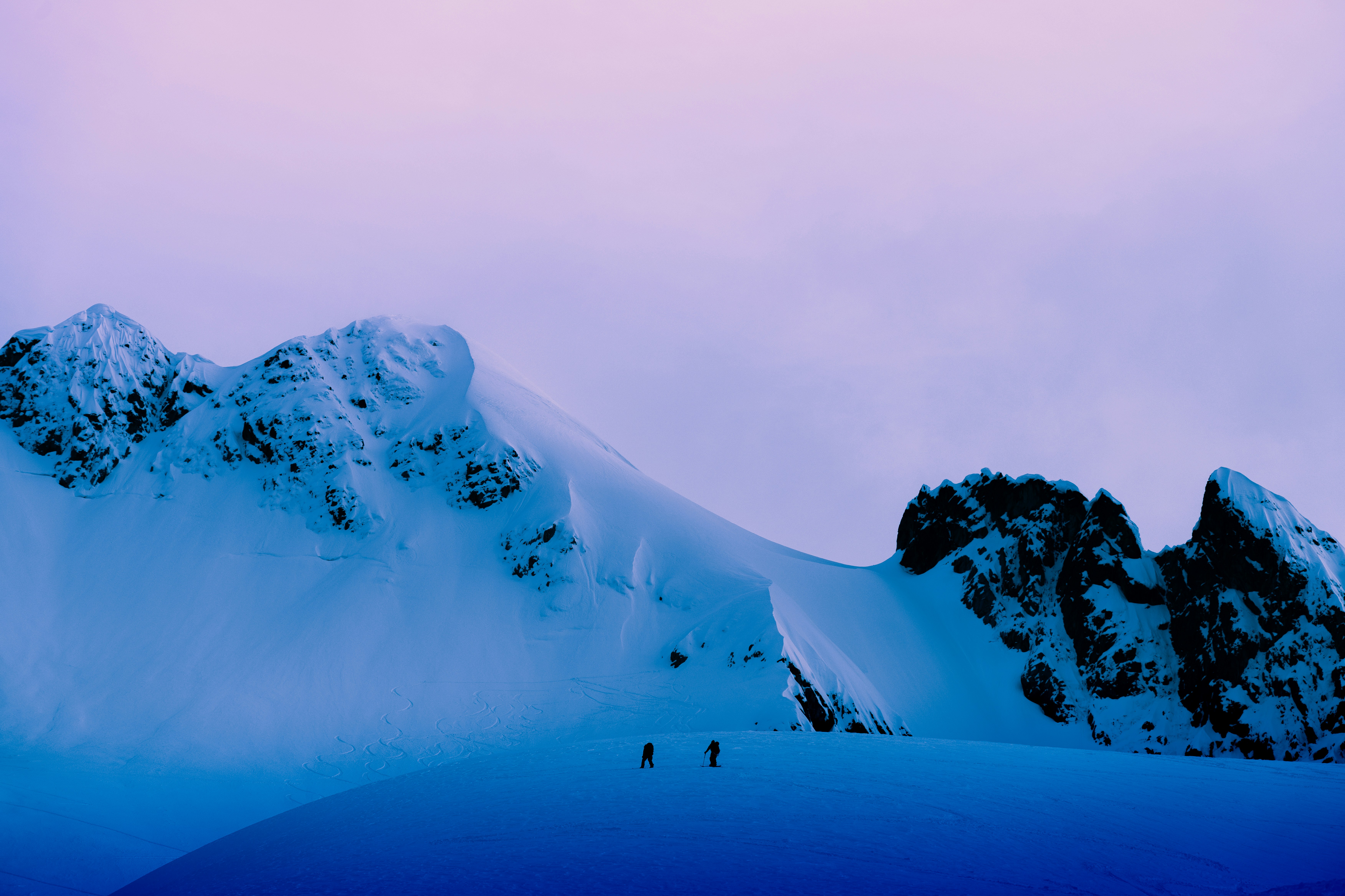 Two people on a vast snowy mountain landscape