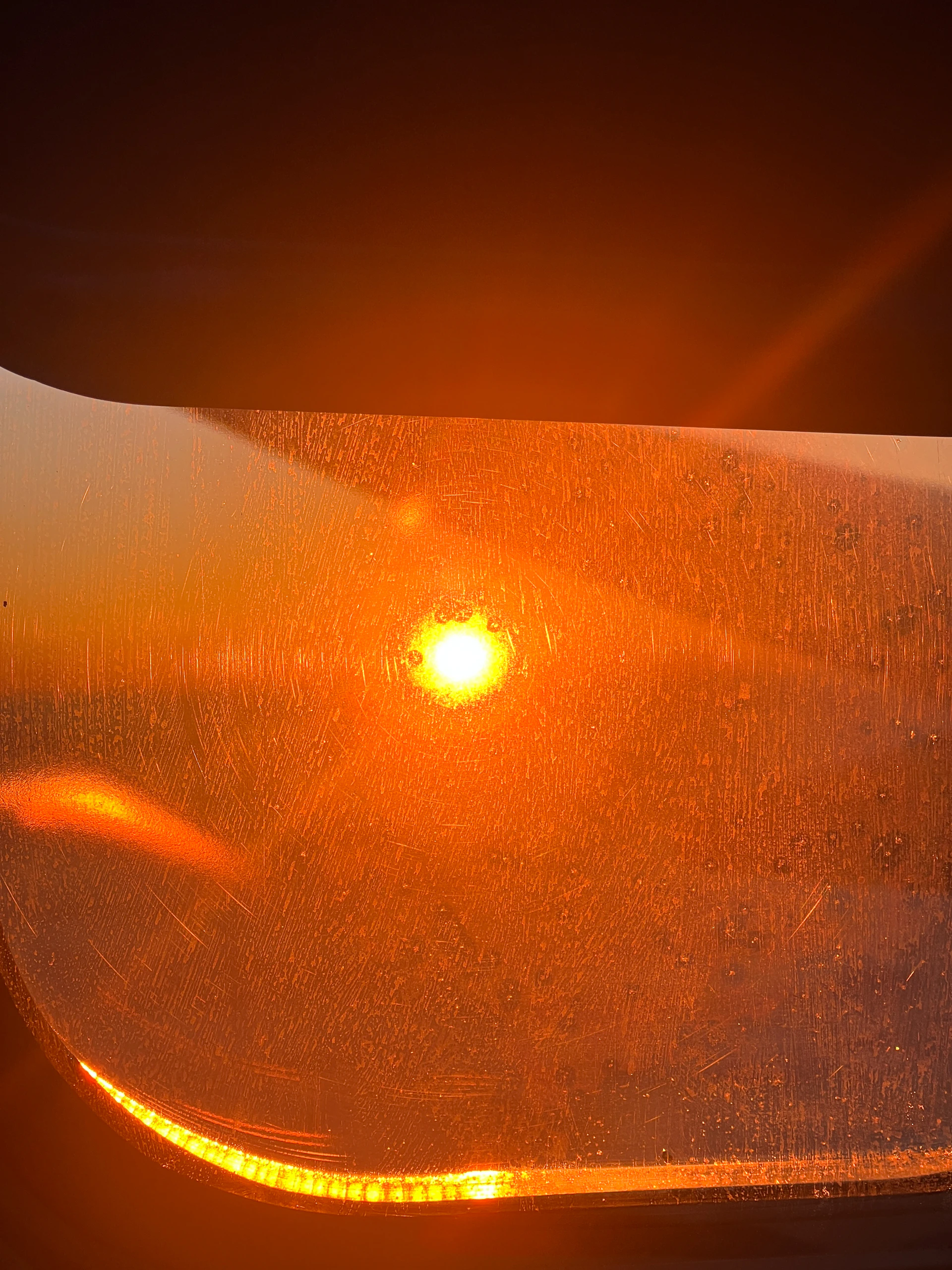 Bright orange sun shining through a textured window