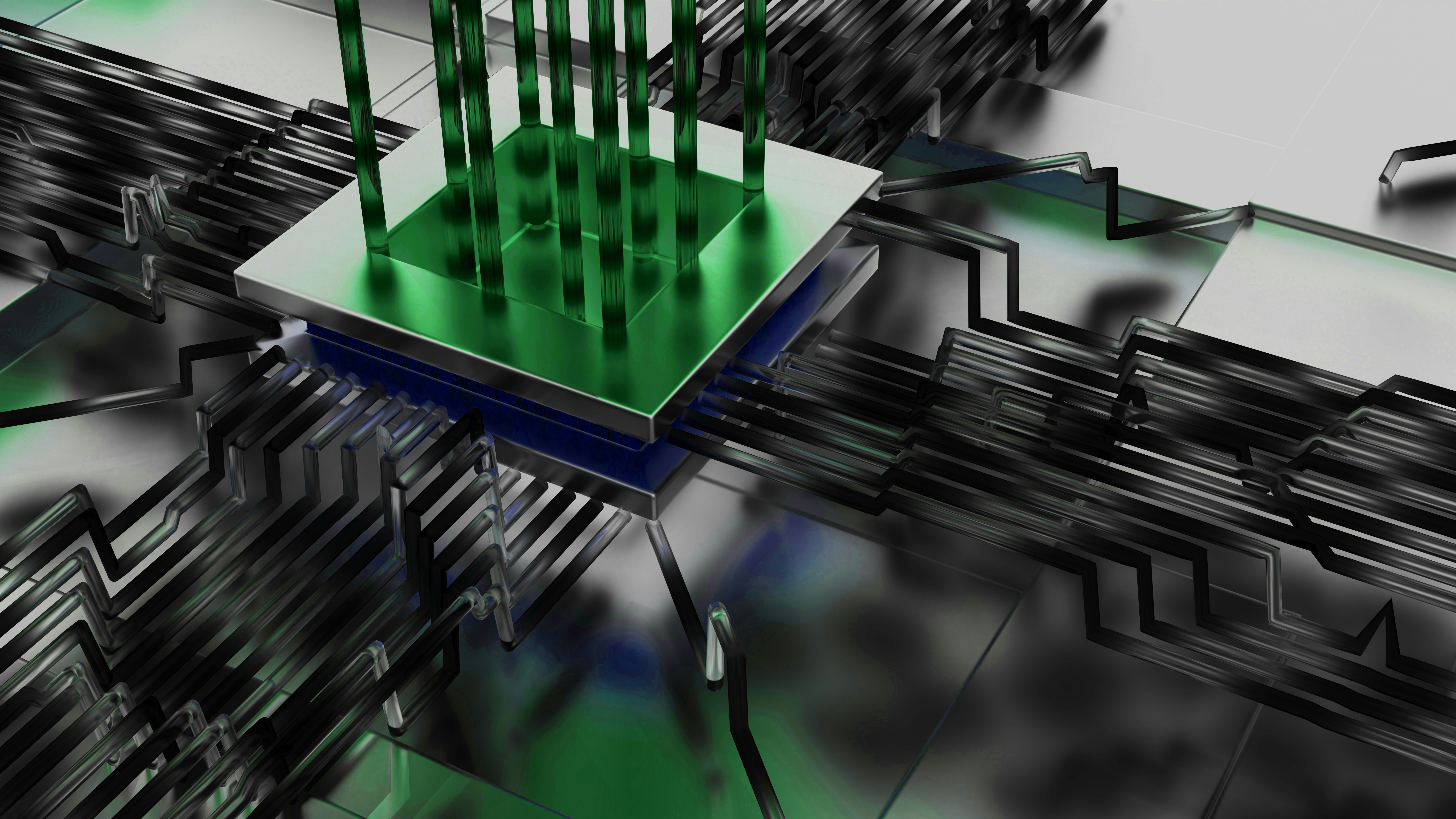 A green microchip with pins on a dark circuit board.
