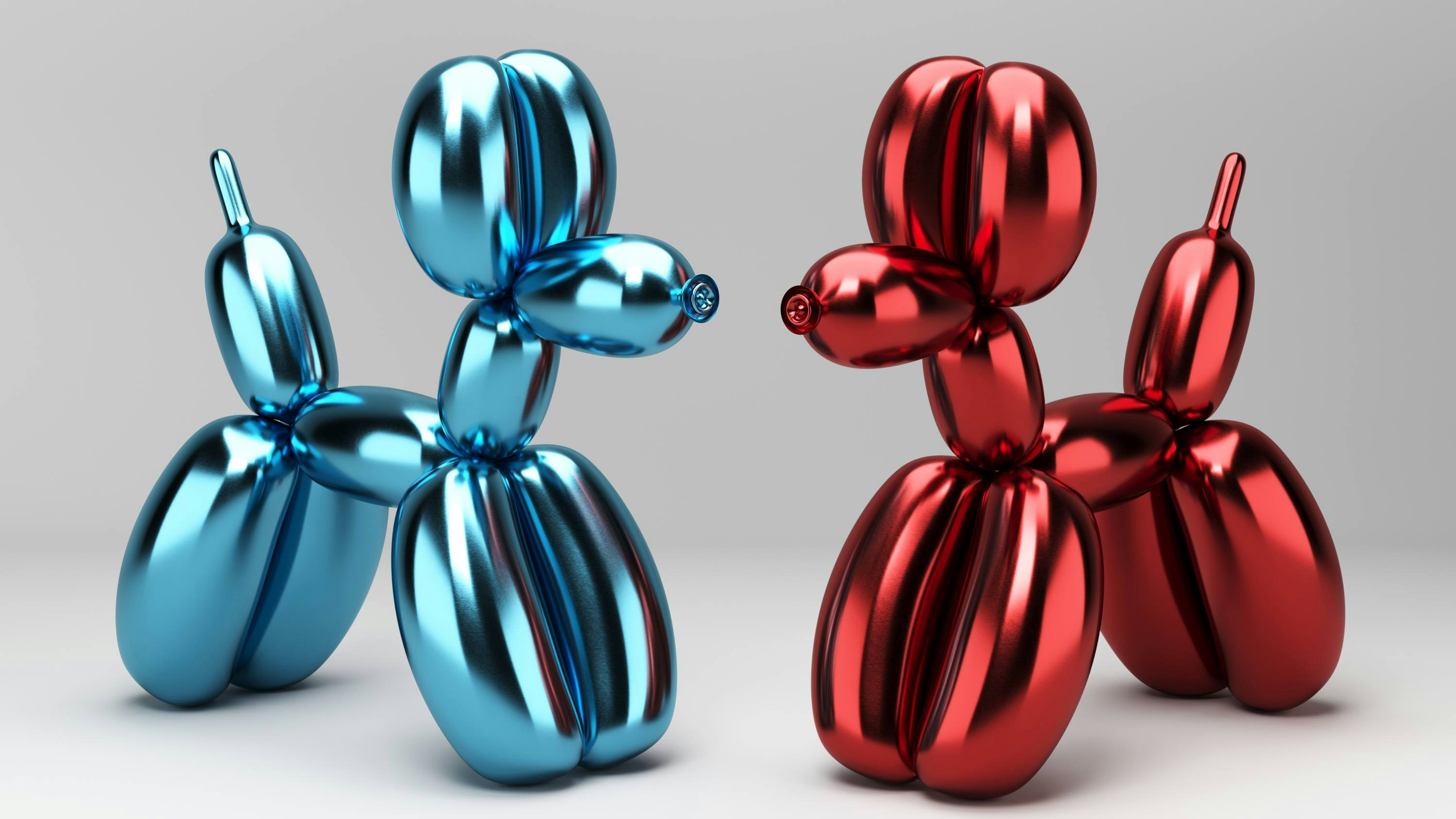 Blue and red metallic balloon dog sculptures facing each other.