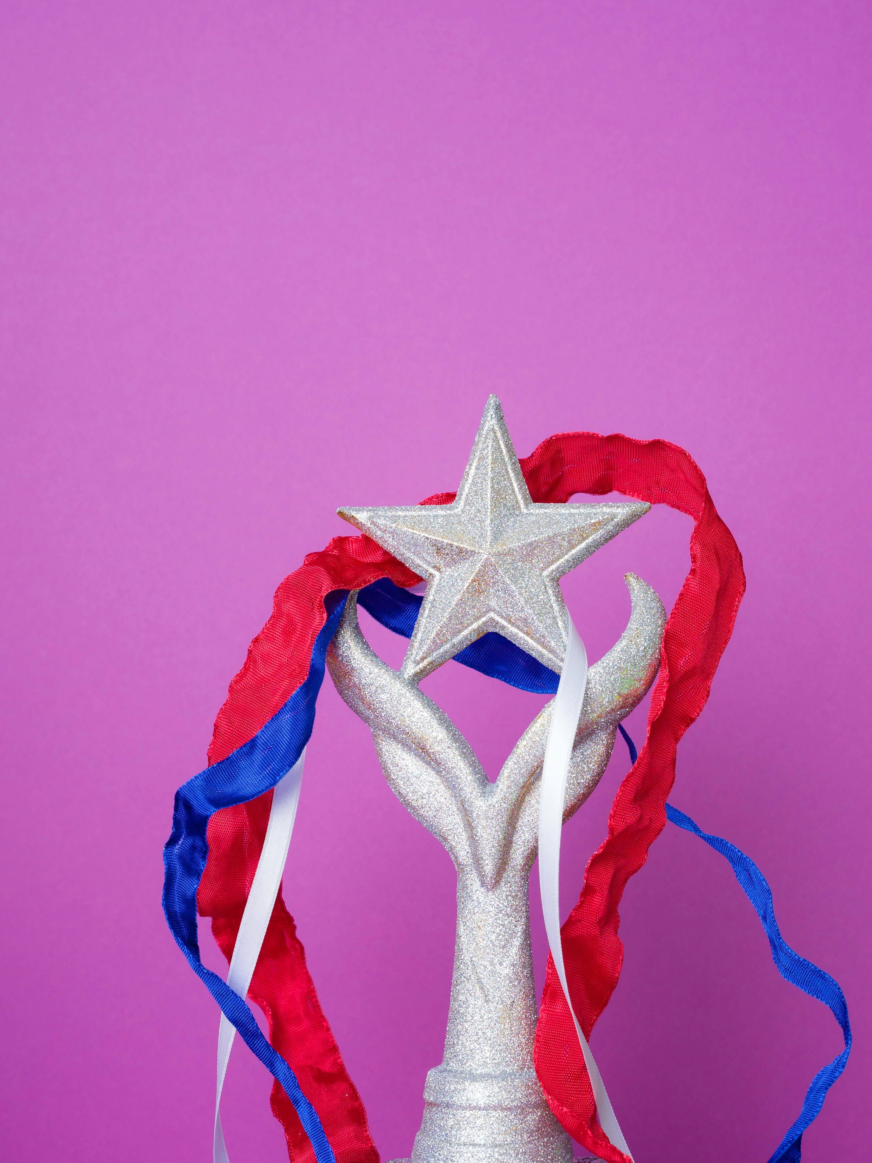 Silver star trophy with patriotic ribbons on purple