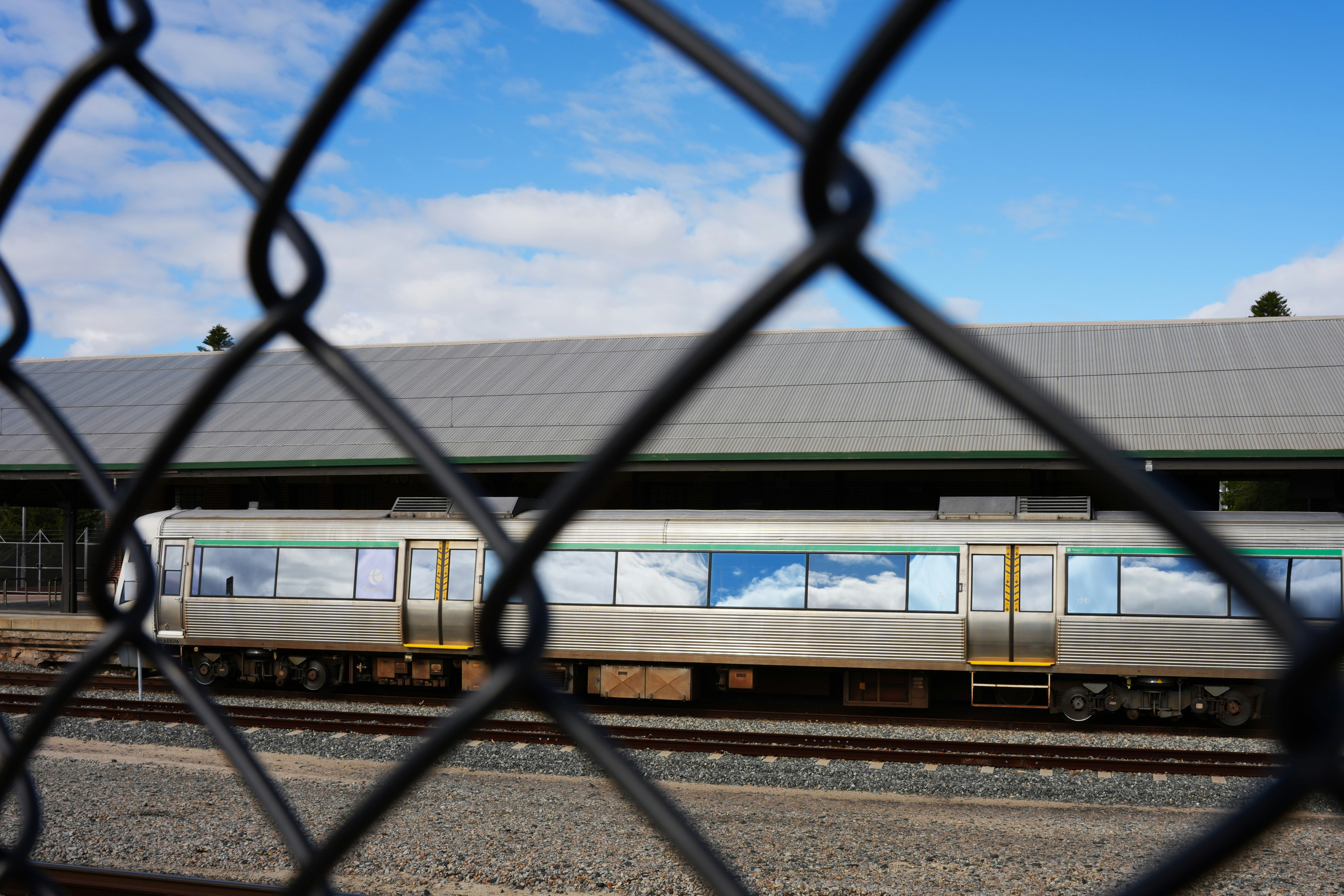 Train seen through a chain-link fence