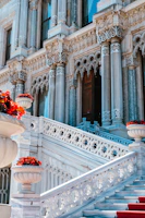 Ornate marble palace with grand staircase and red flowers