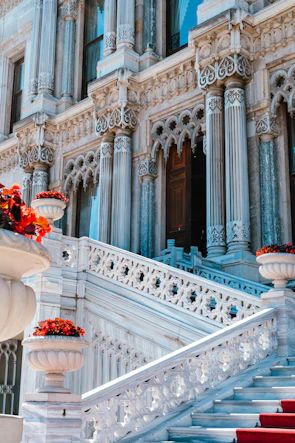Ornate marble palace with grand staircase and red flowers