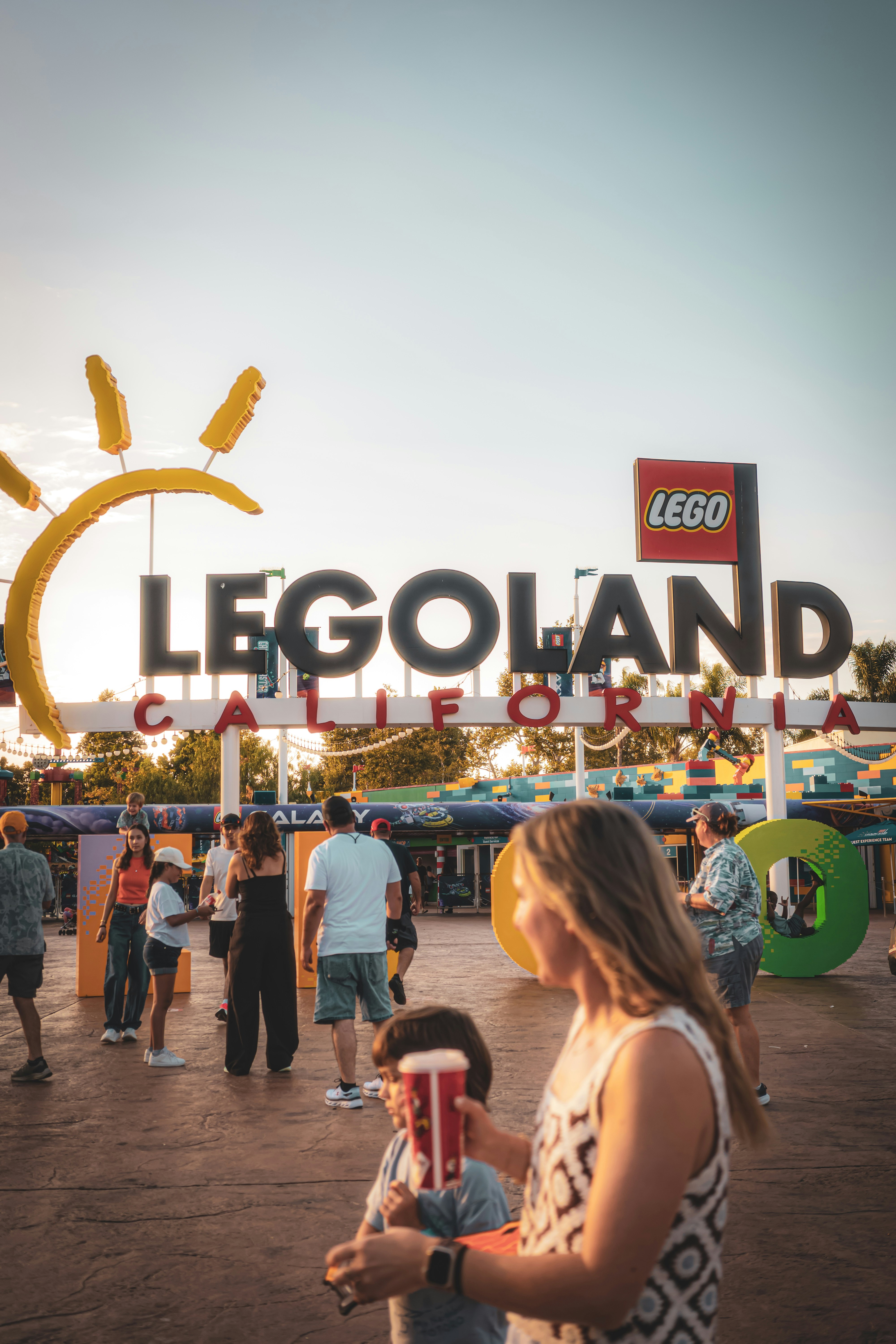 People gathered near the legoland california sign at sunset