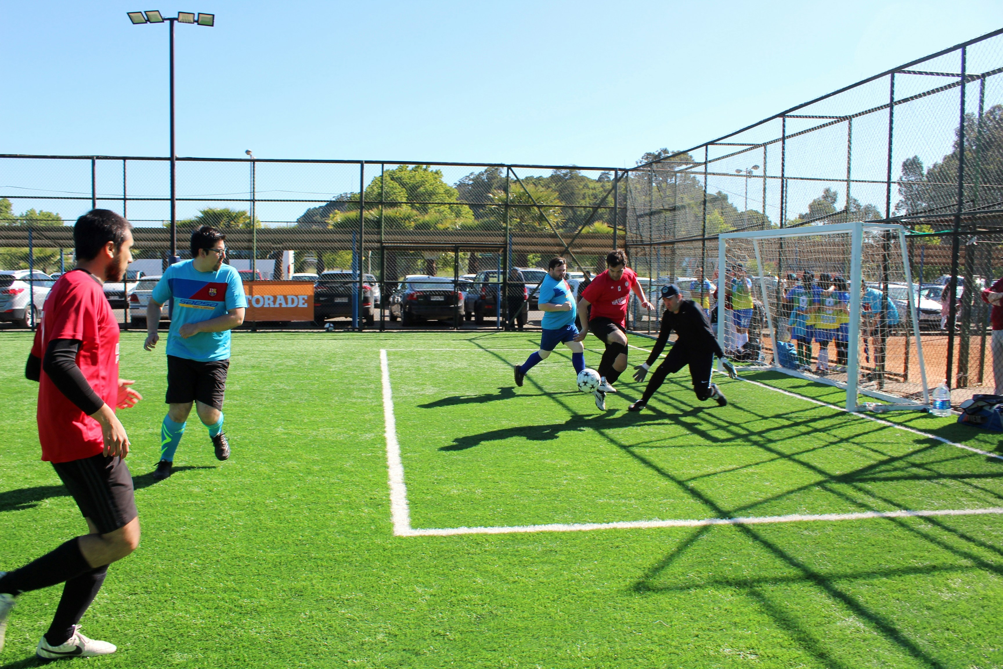 People playing a soccer match on an outdoor artificial turf field