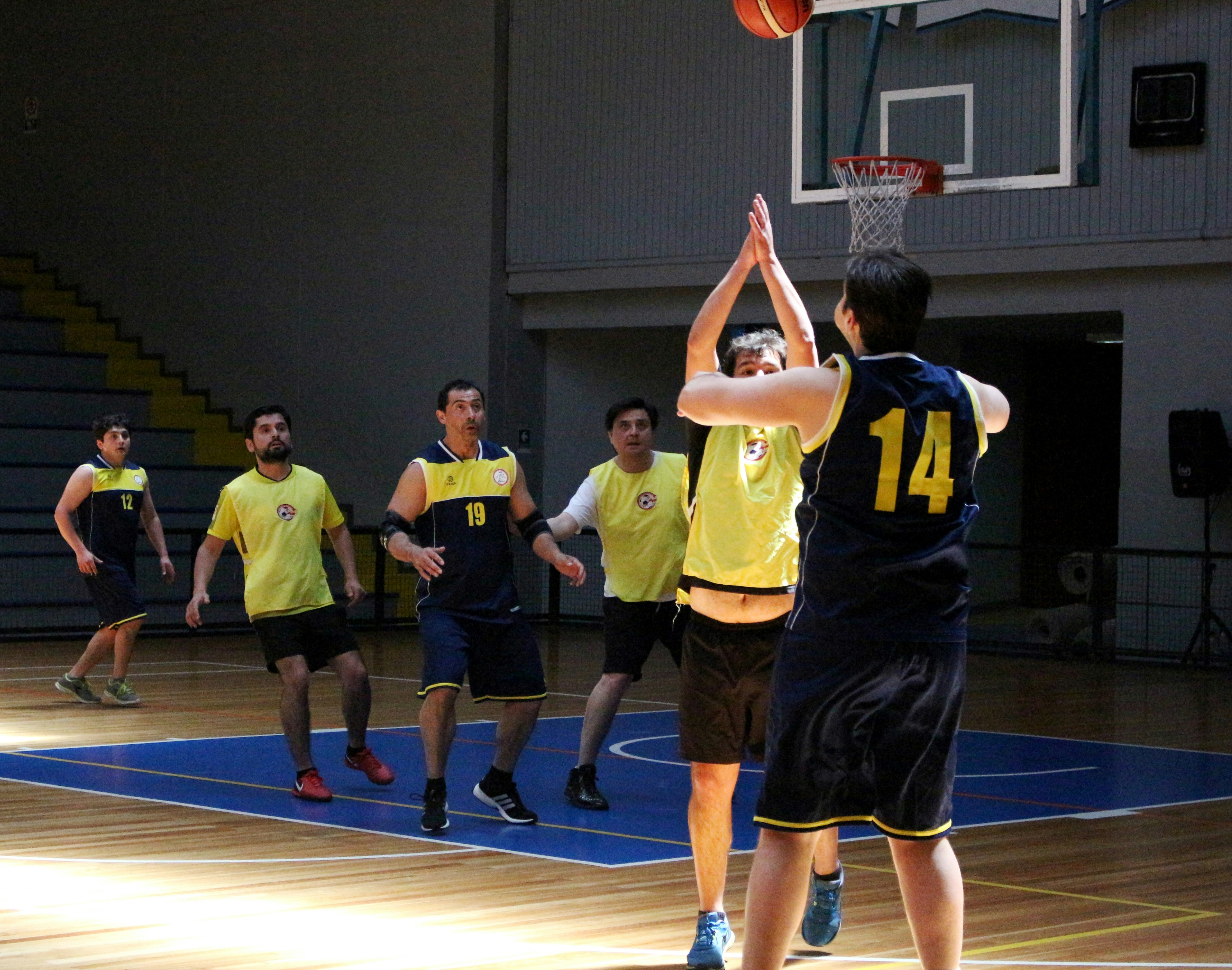 A group of men playing basketball on an indoor court