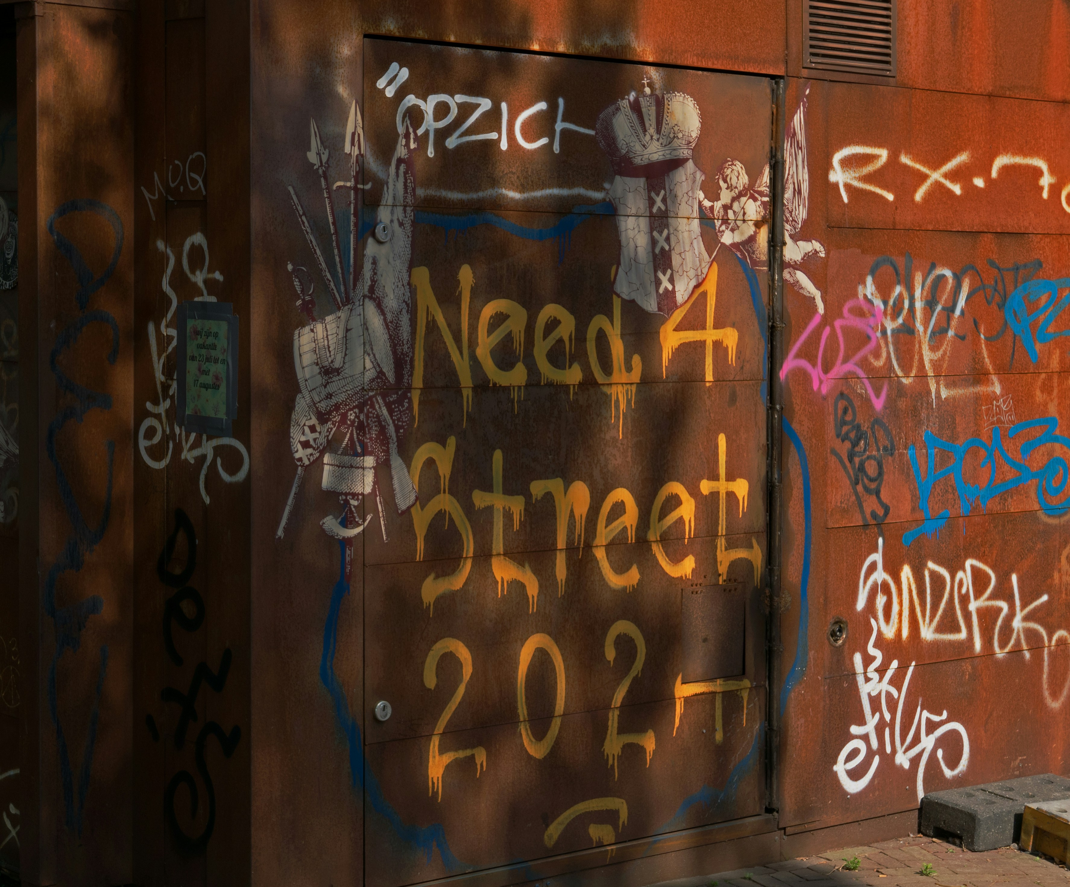 Grafiti "need 4 street 2022" en un muro urbano oxidado.