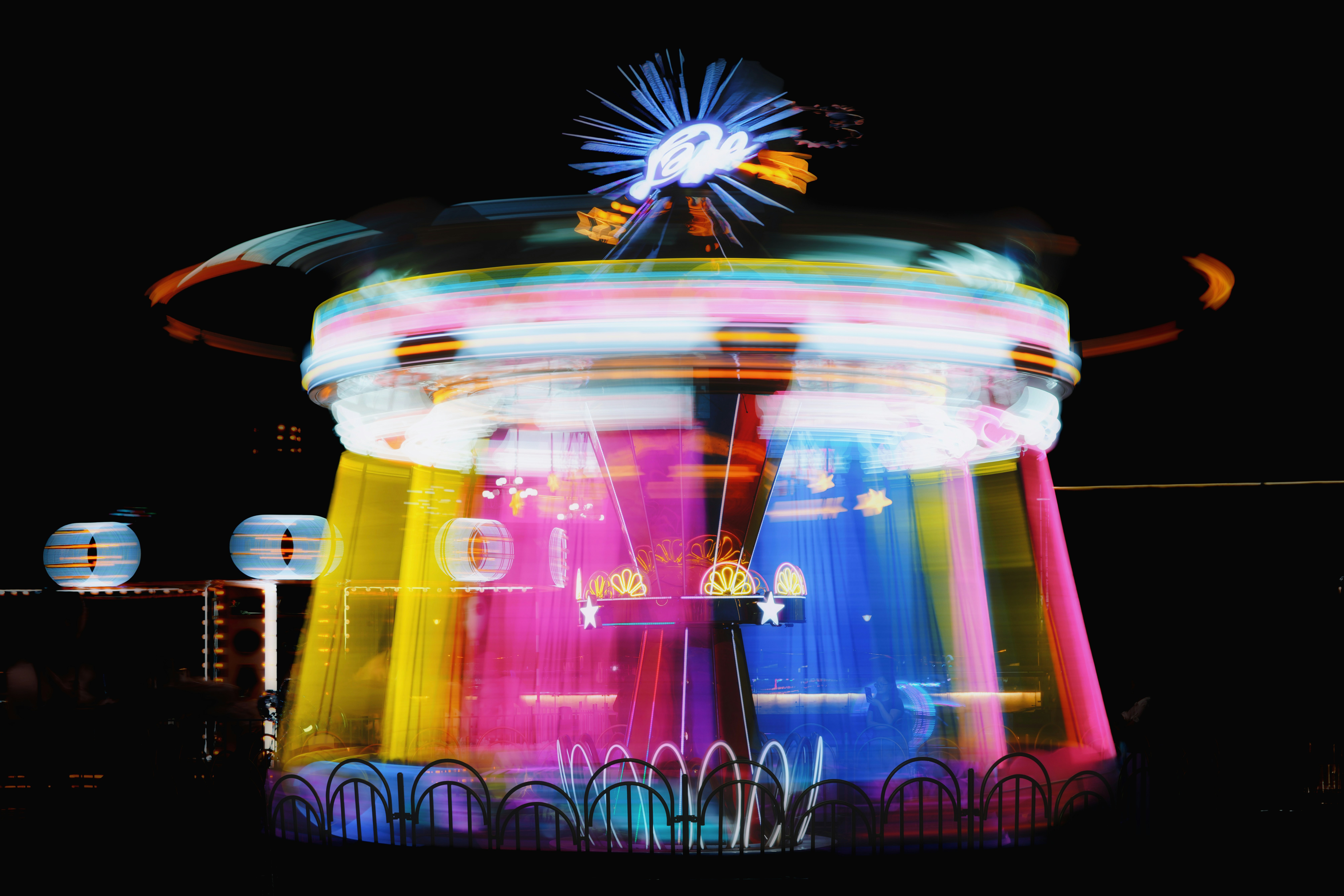 Colorful blurred amusement park ride lights at night