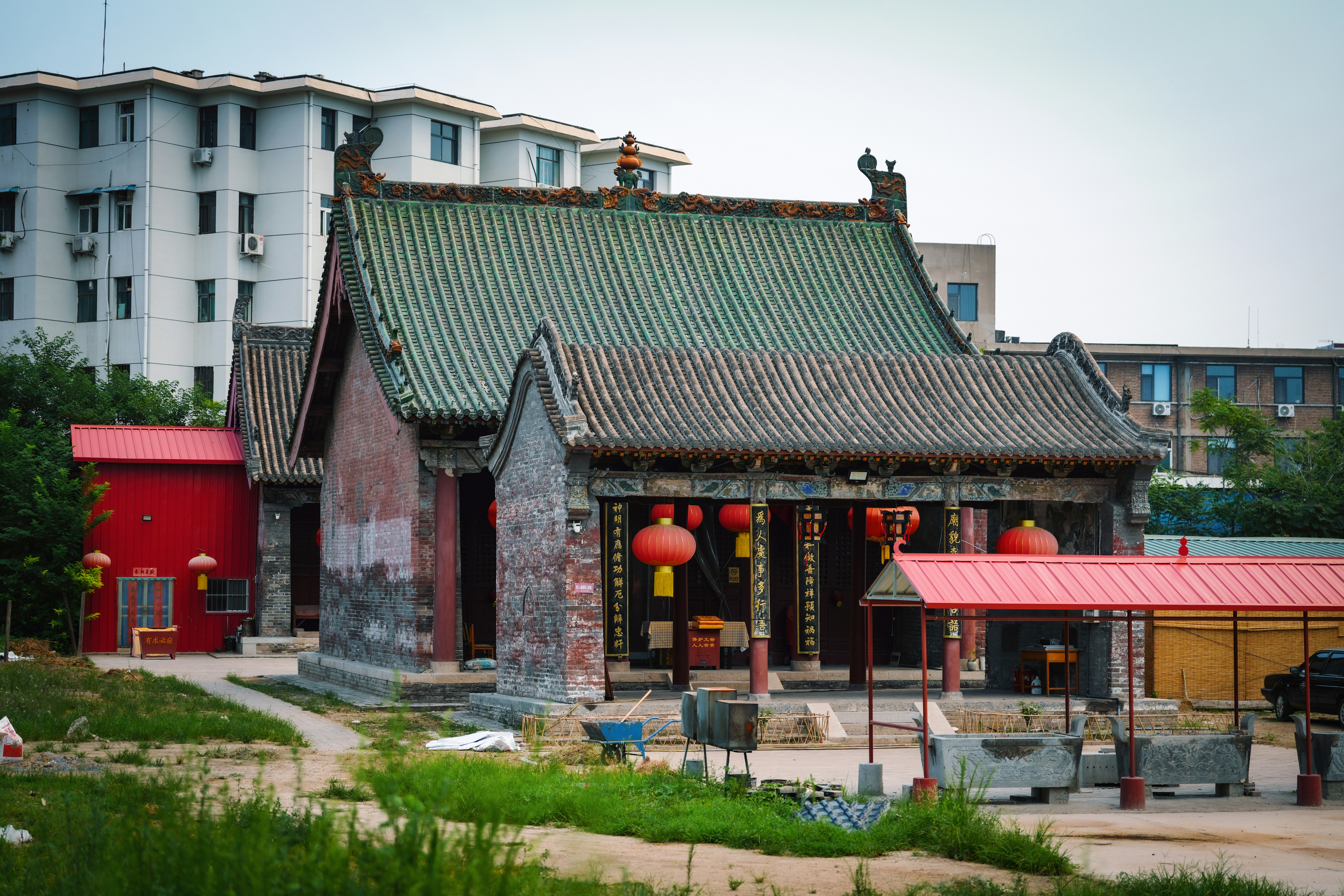 Traditional chinese temple with red lanterns and modern buildings