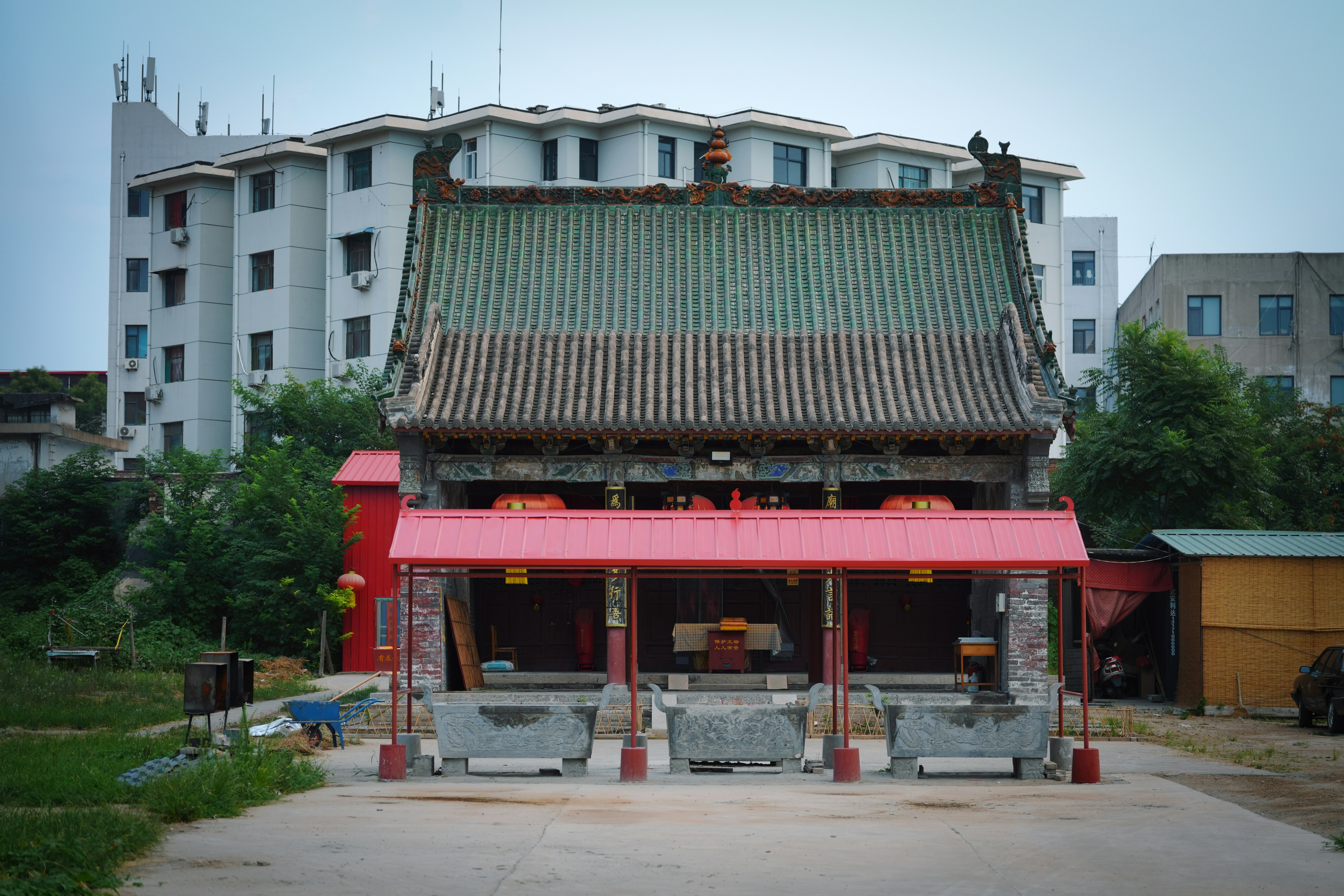 Traditional chinese building with green roof and red awnings.