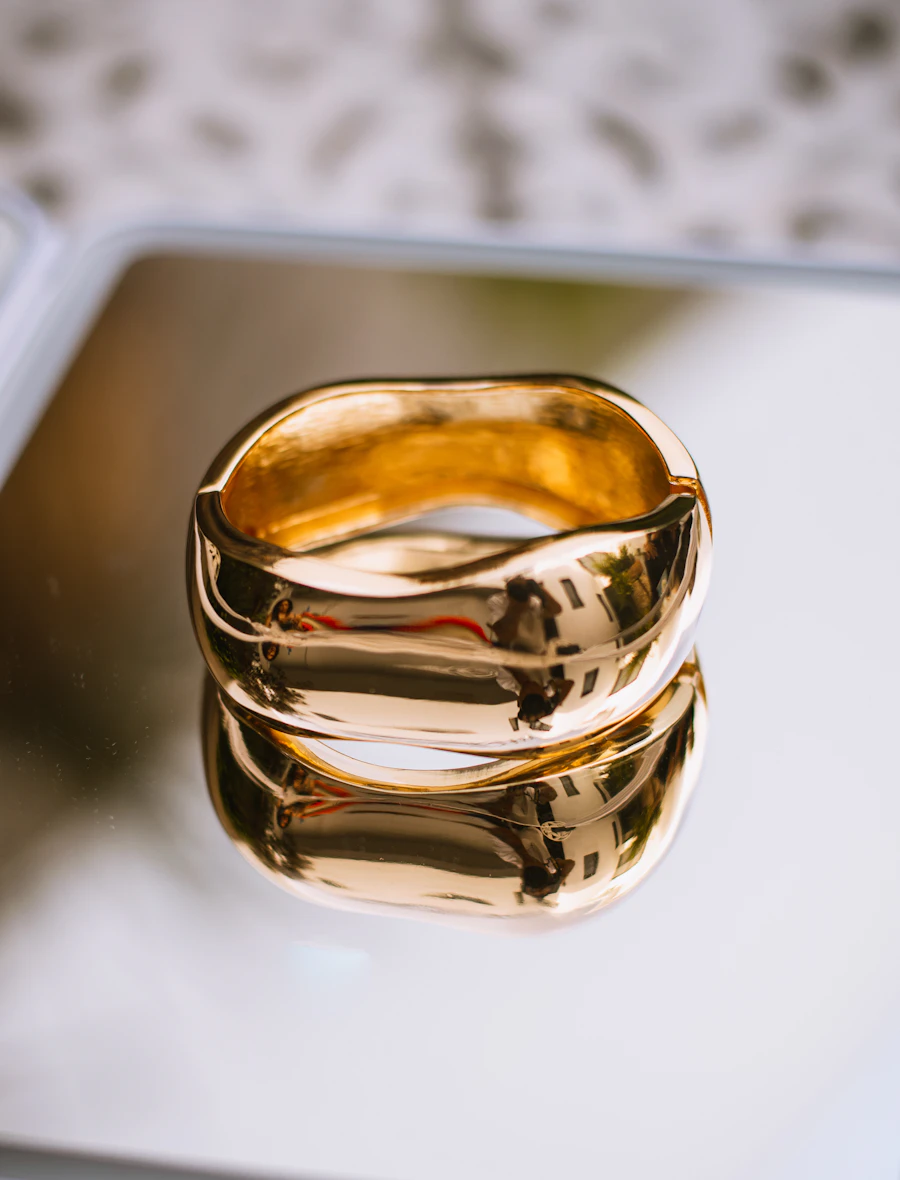 Anillo de oro de forma orgánica reflejado en un espejo