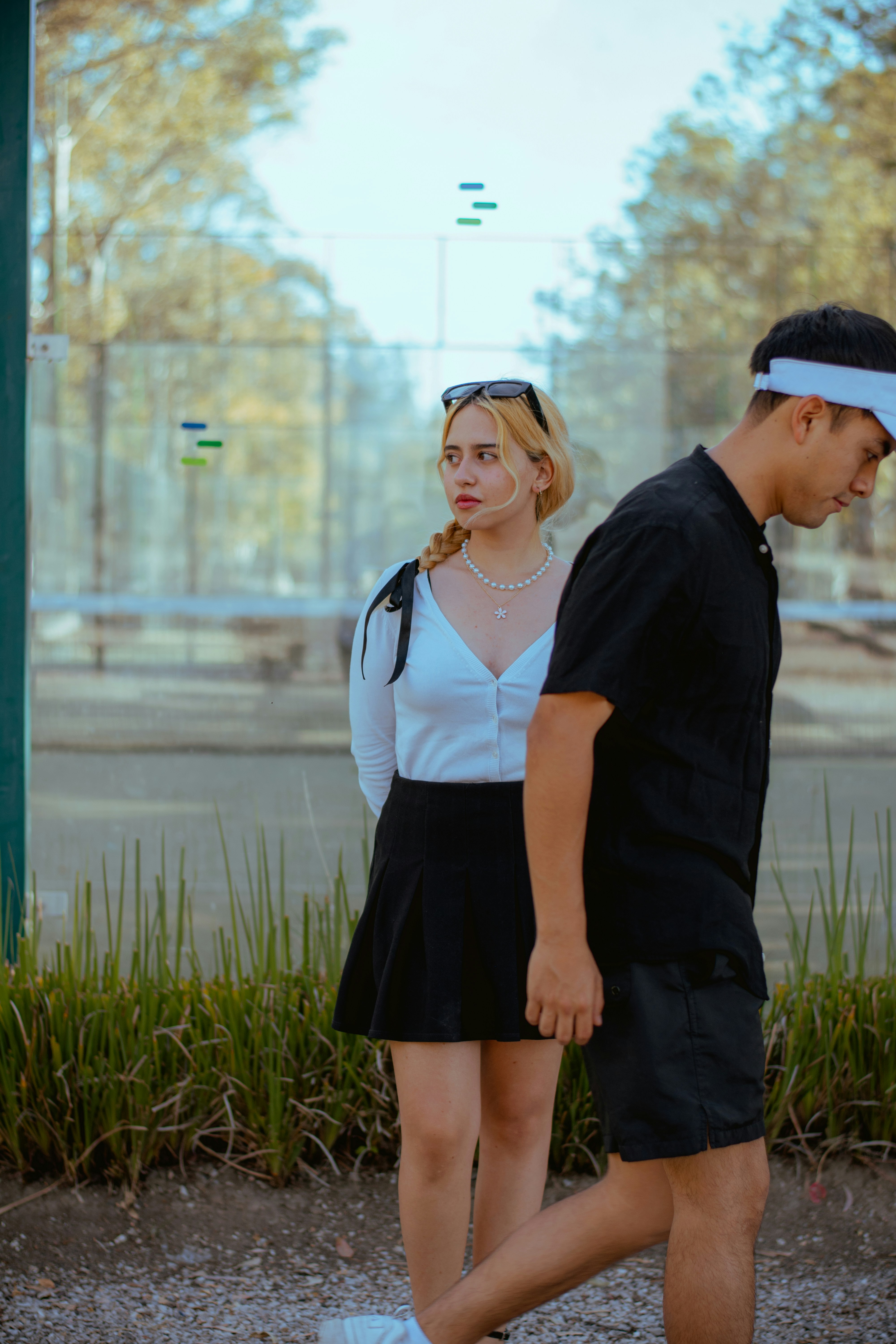 Woman looking left as man walks past outdoors