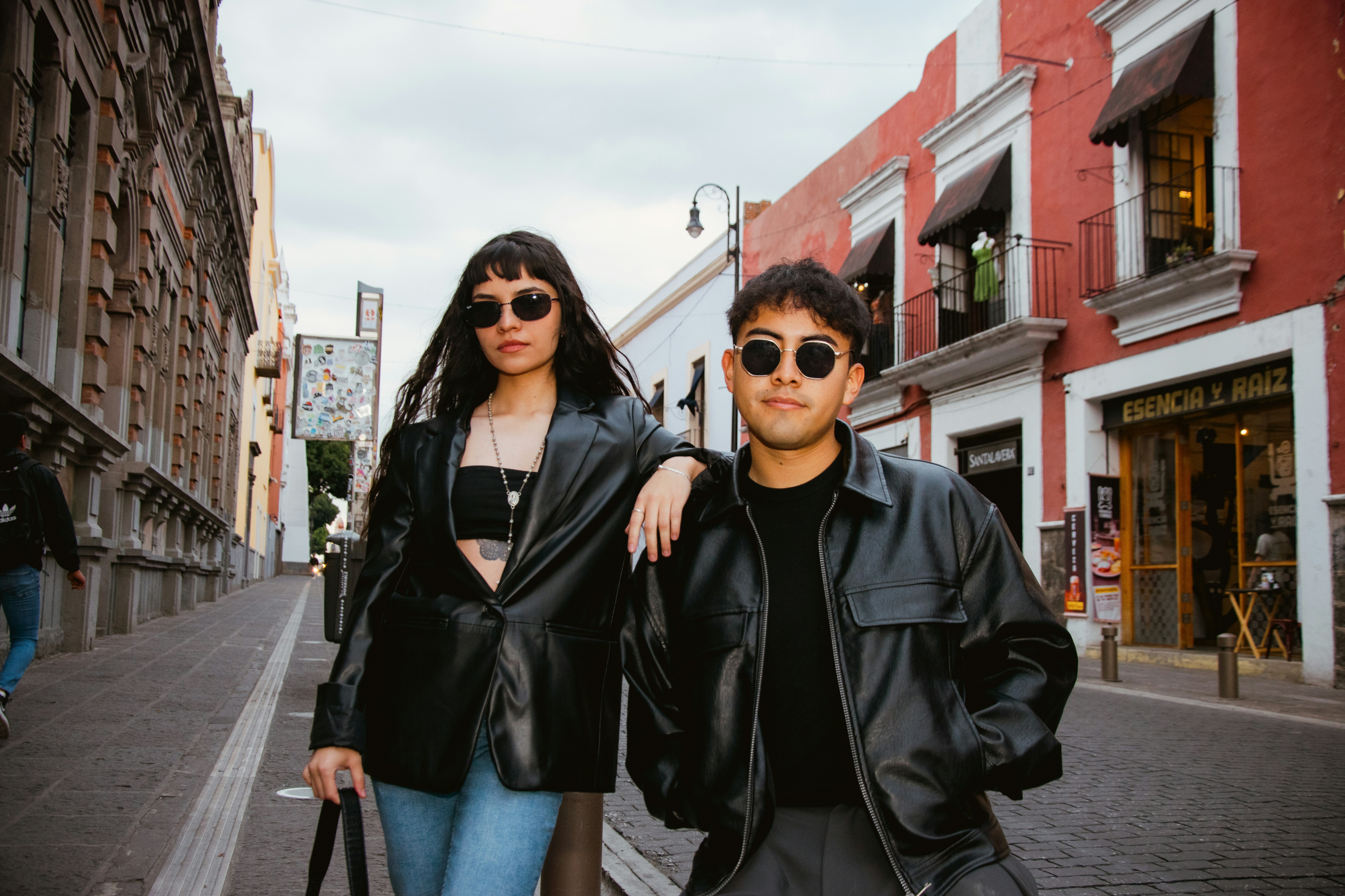 Dos personas con estilo con chaquetas de cuero en una calle urbana