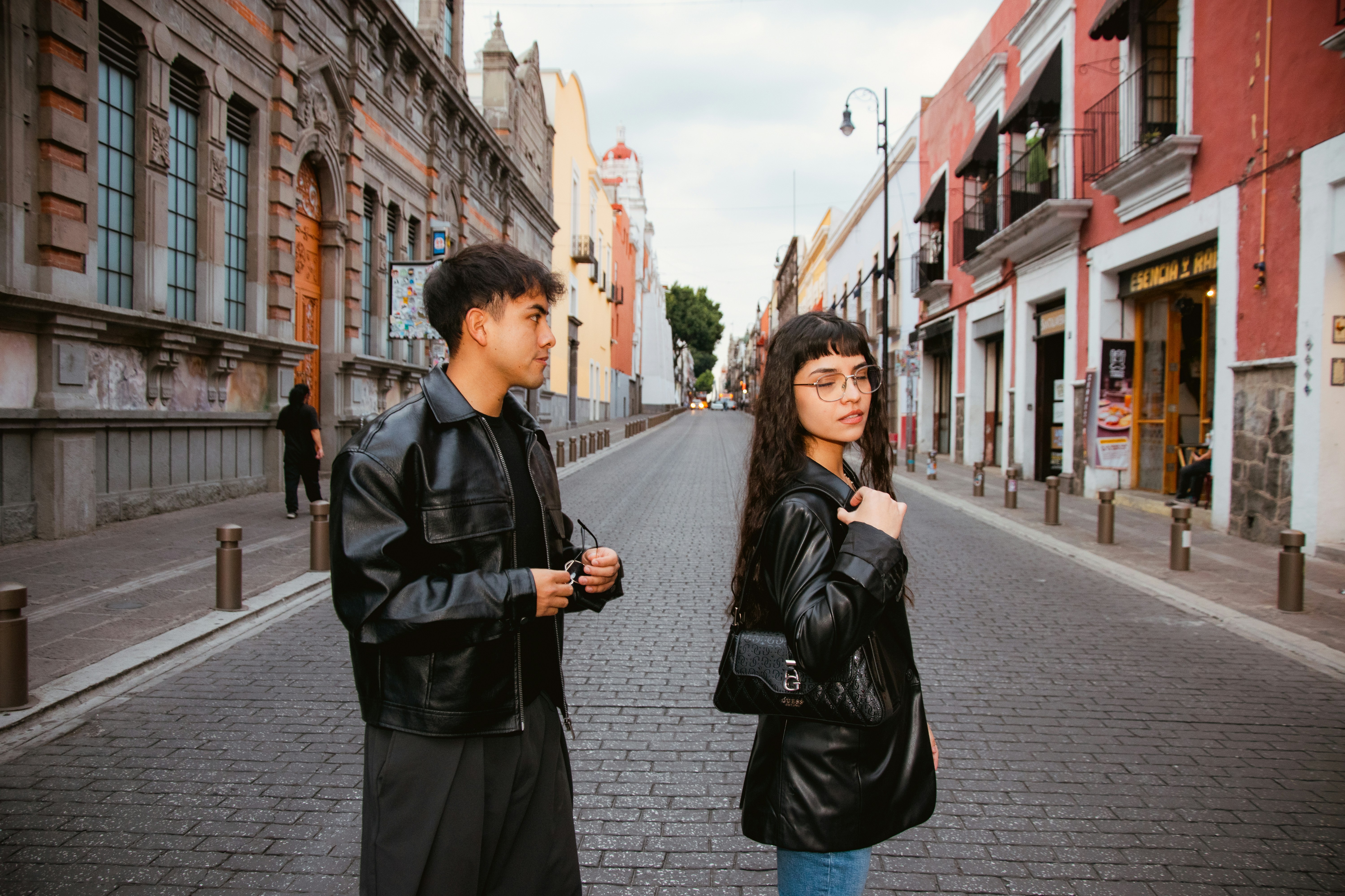Man and woman in leather jackets on a cobblestone street