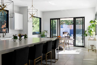 Modern kitchen with large island, bar stools, and outdoor patio