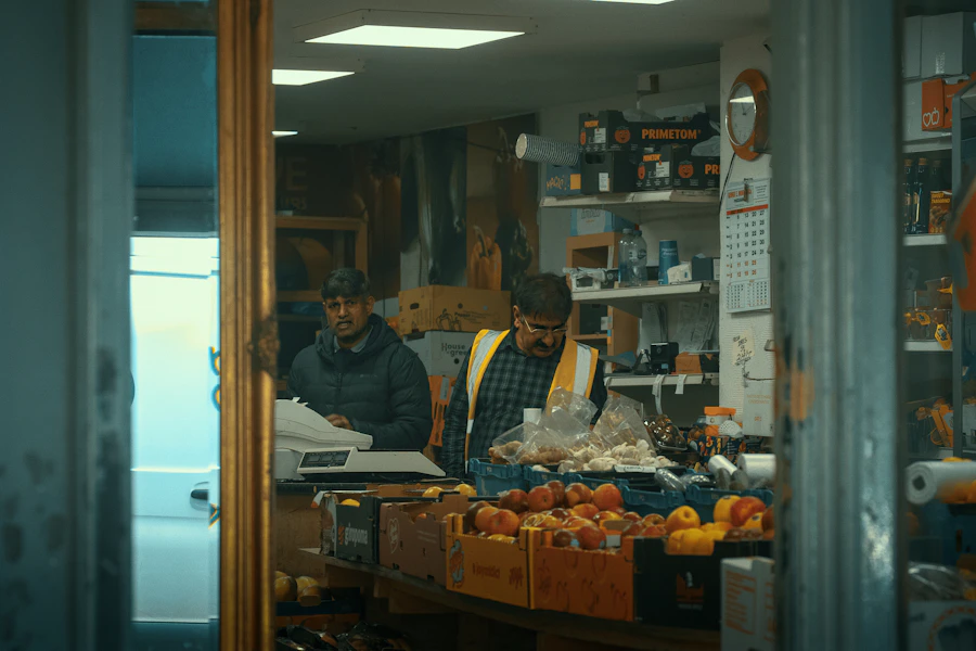 Two shopkeepers in a small shop with fresh produce
