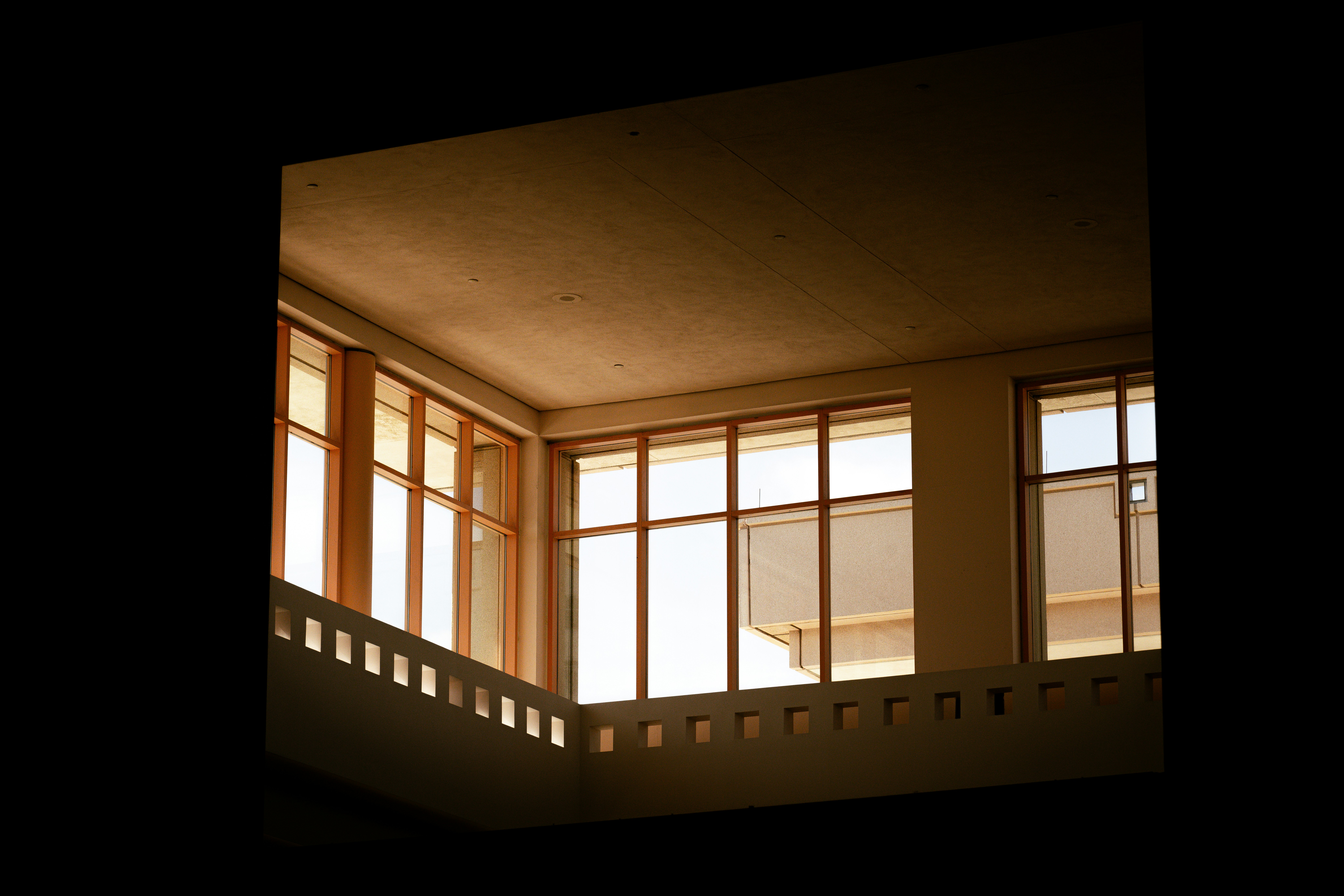 Large windows with orange frames in a modern building interior