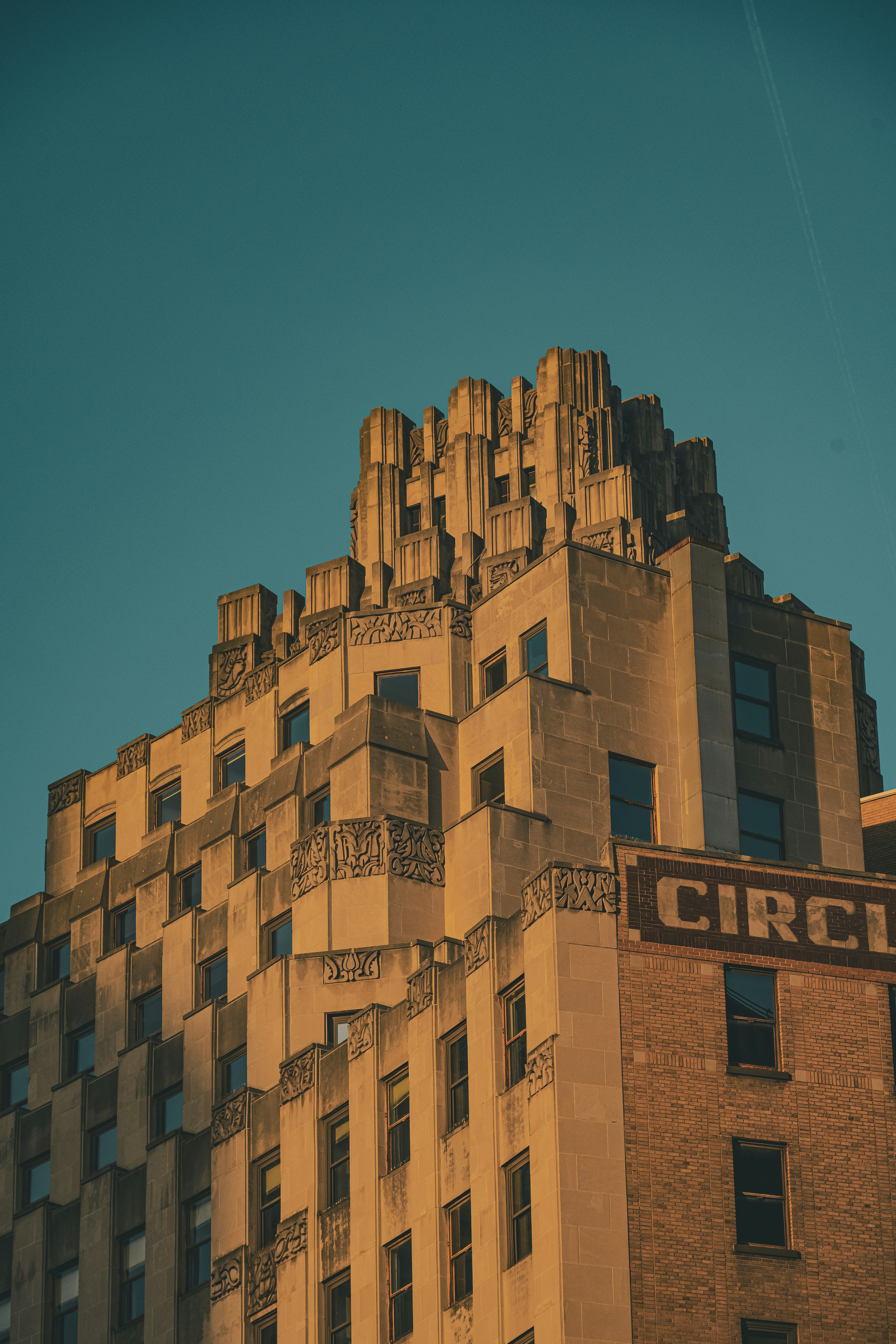 The stepped stone facade of an Art Deco building against a clear blue sky