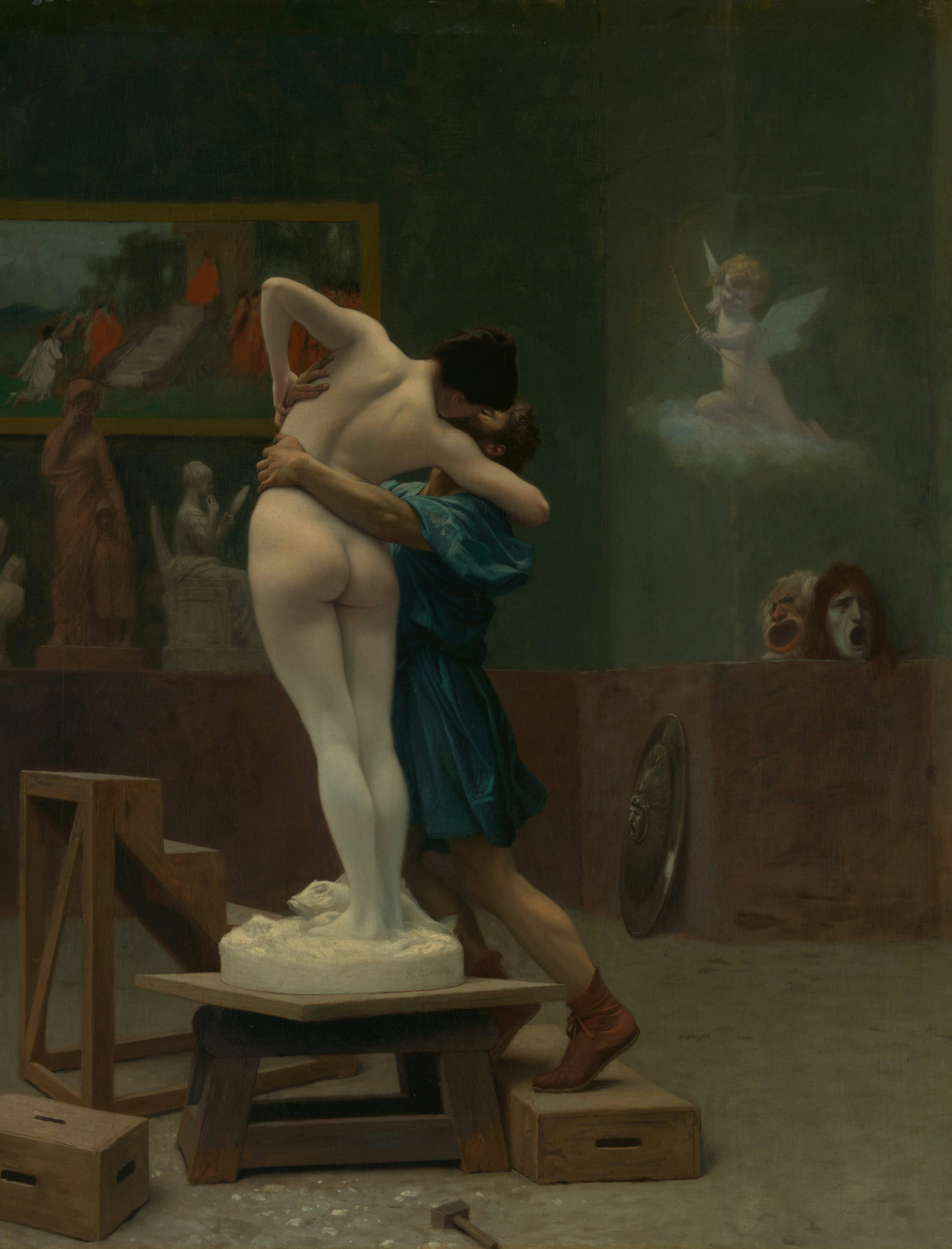 A person in a blue tunic embracing a white marble statue in a studio.