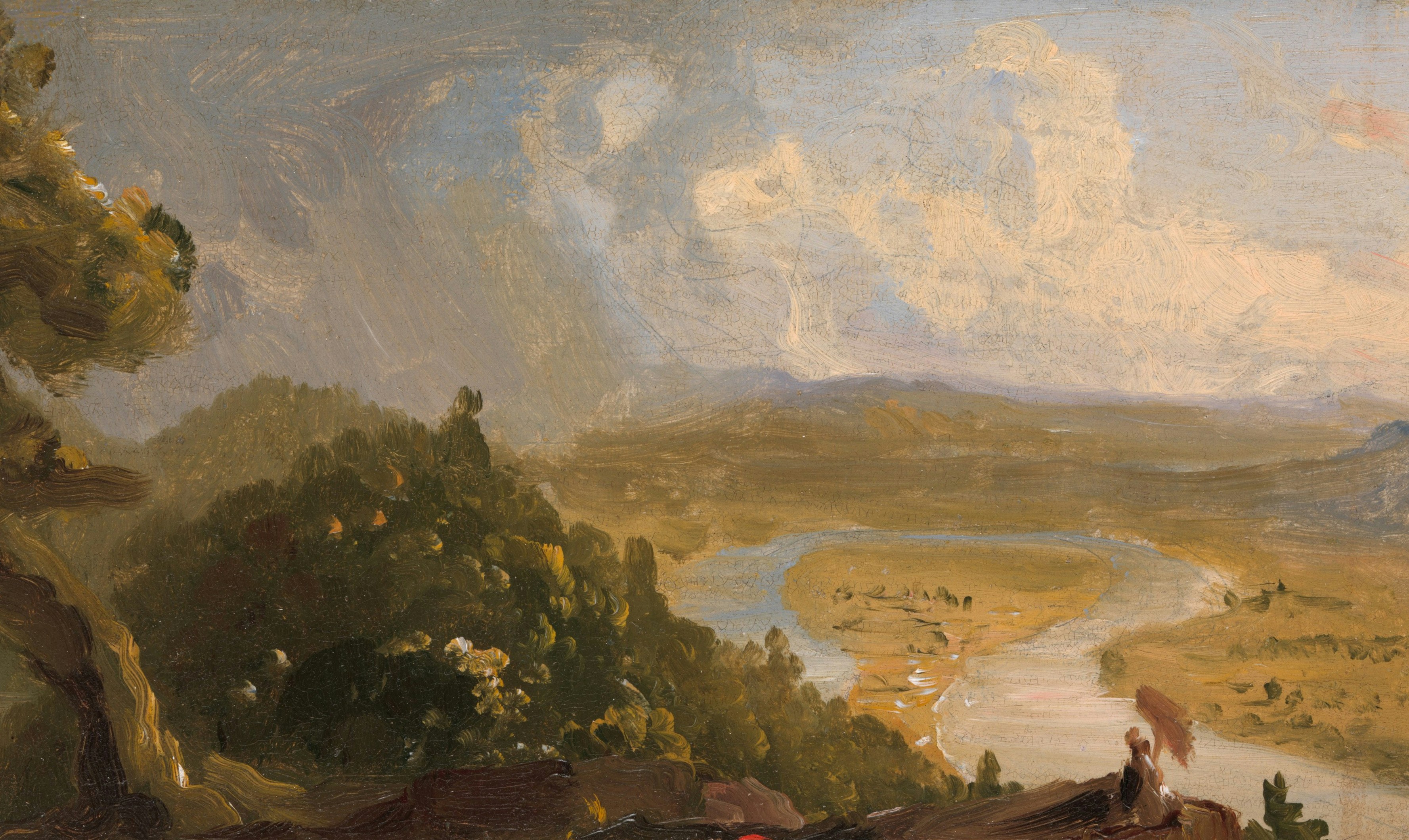 A winding river through a valley with a person holding an umbrella nearby.