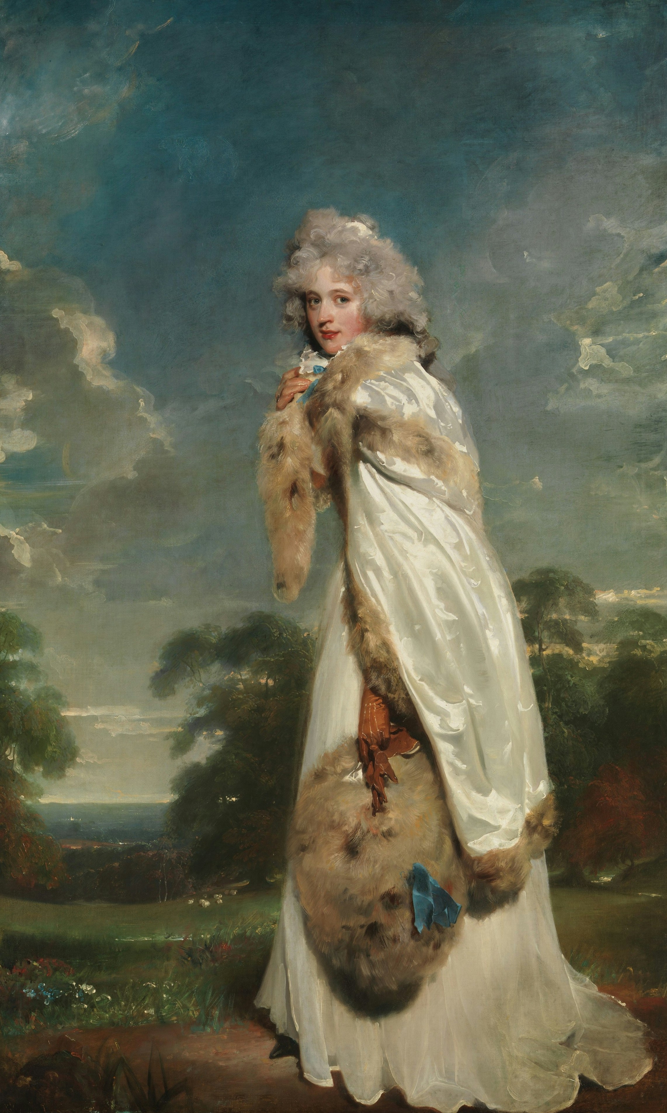 A woman in a white satin coat with fur trim standing in a landscape.
