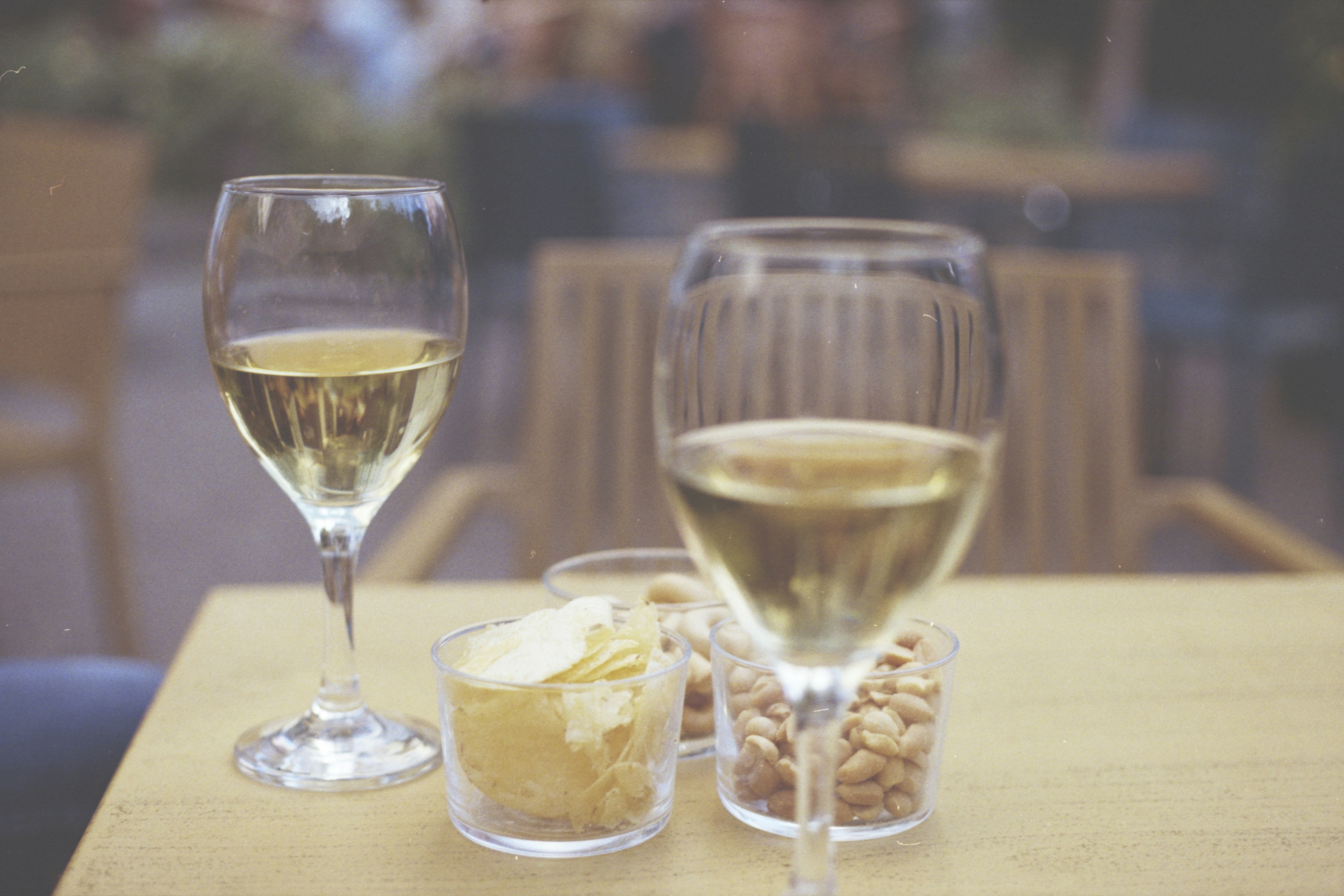 Two glasses of white wine with snacks on a table