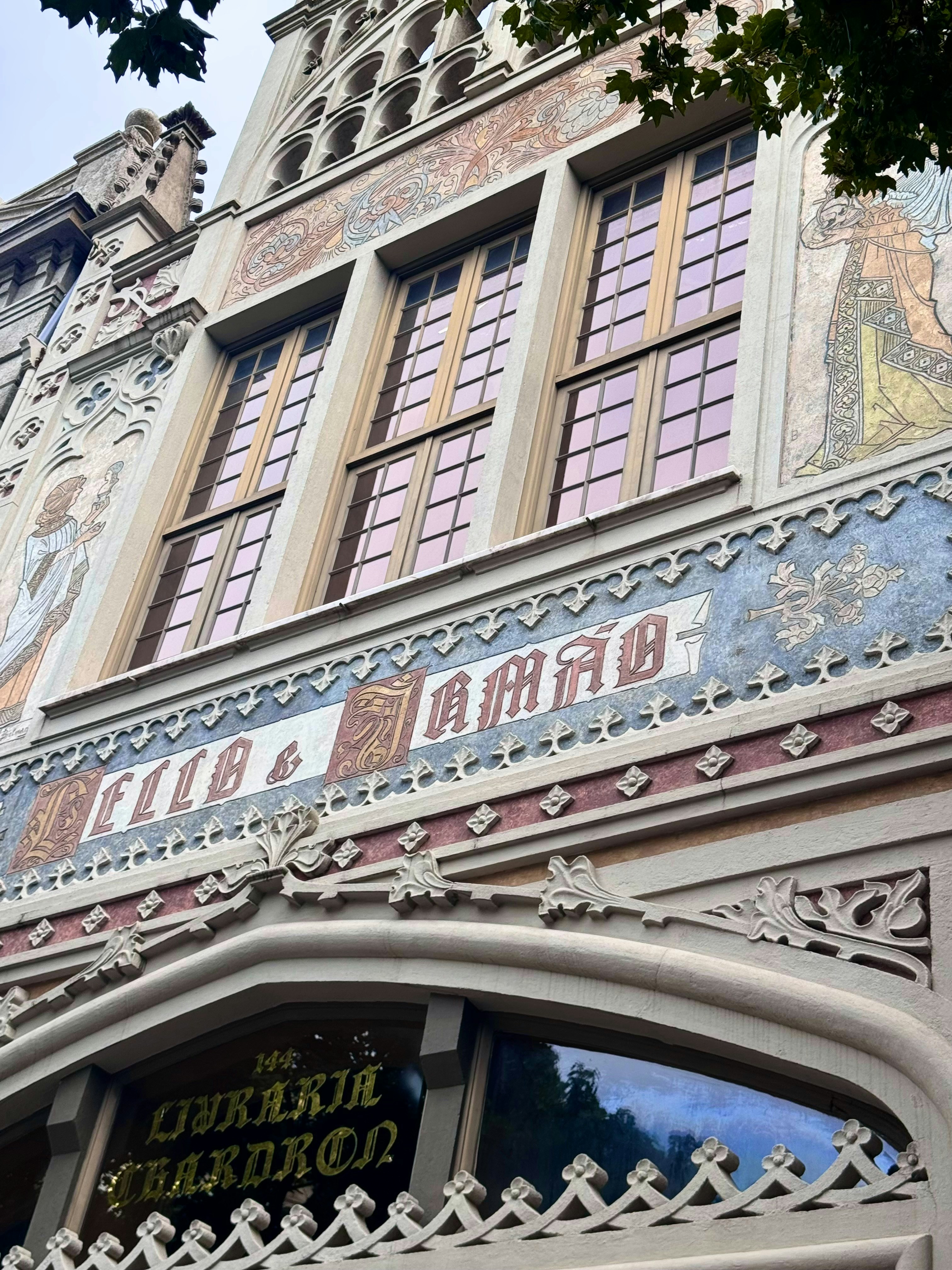 The ornate neo-Gothic facade of Livraria Lello in Porto with intricate carvings and murals.