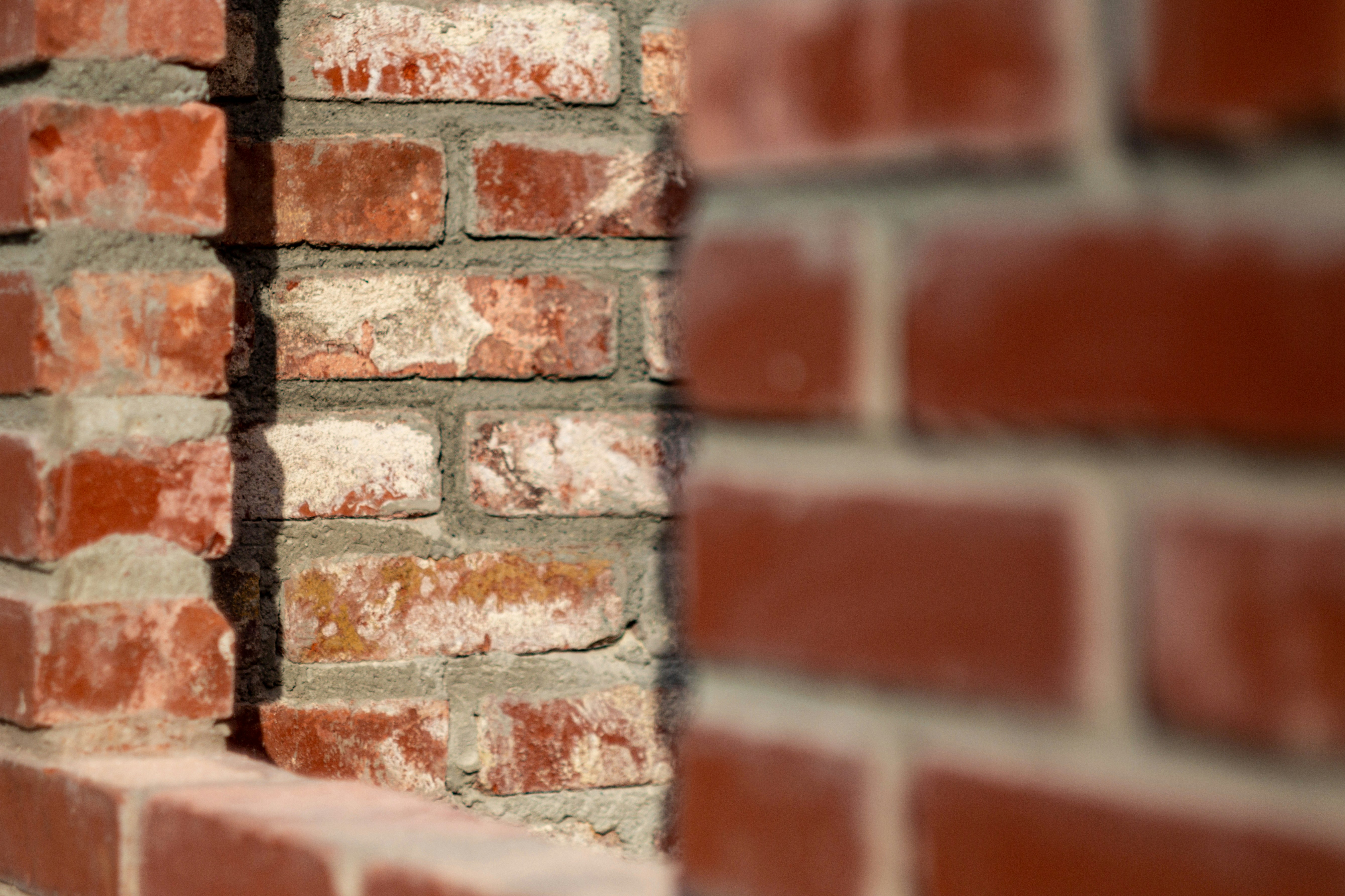 Red brick walls with deep shadows and weathered mortar joints.
