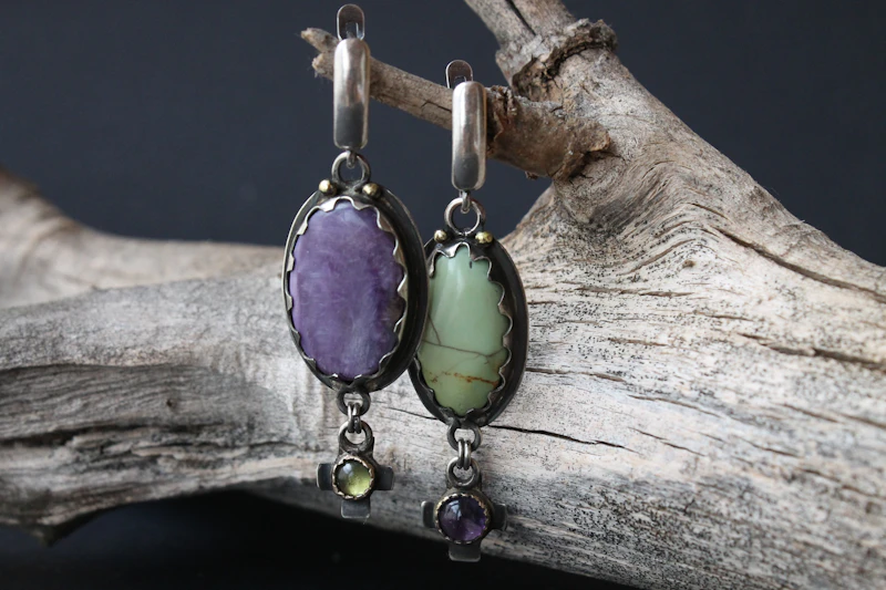 Pendientes de plata con una amatista ovalada y una prehnita verde colgados de un tronco