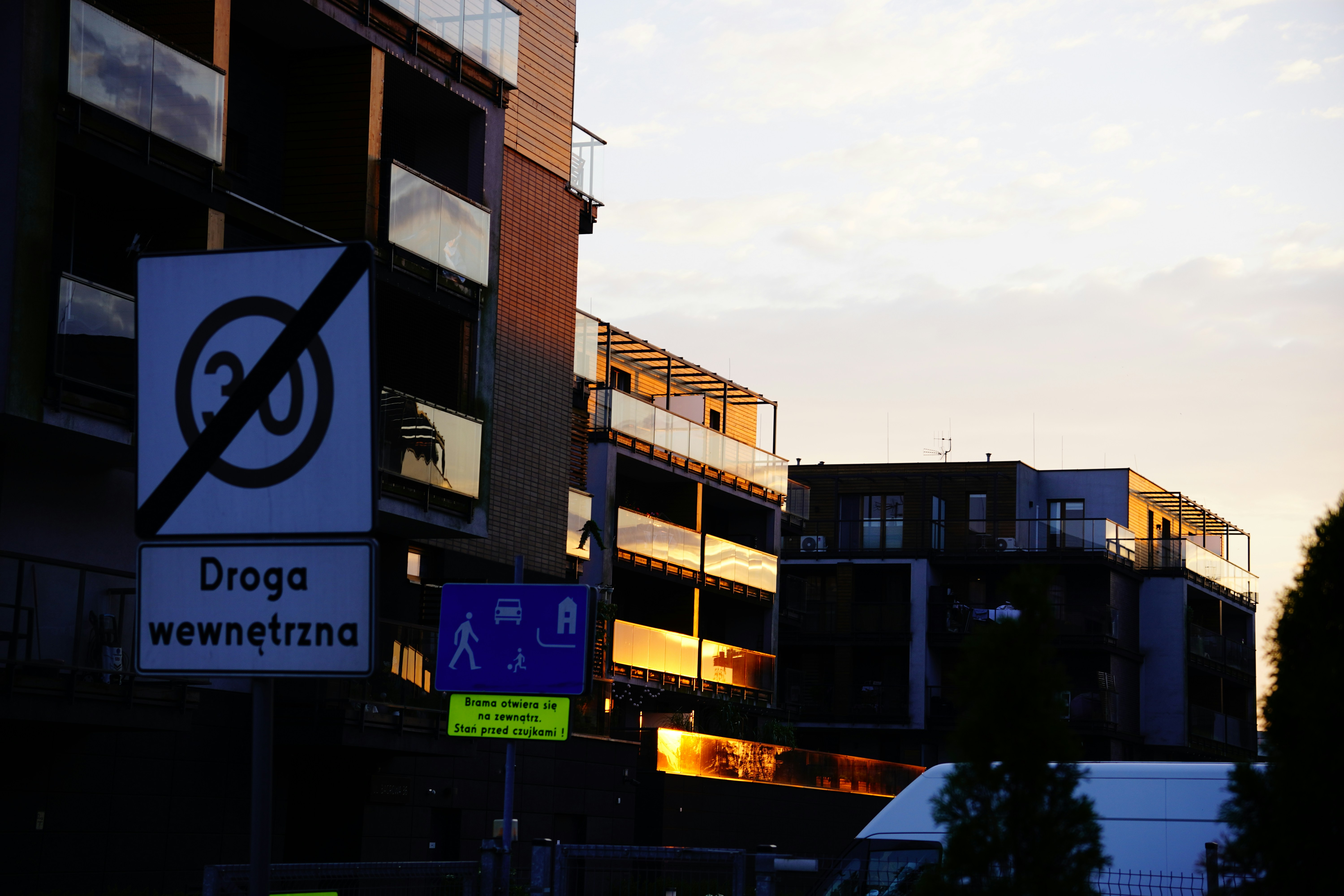 A road sign indicating the end of a speed limit near modern apartment buildings