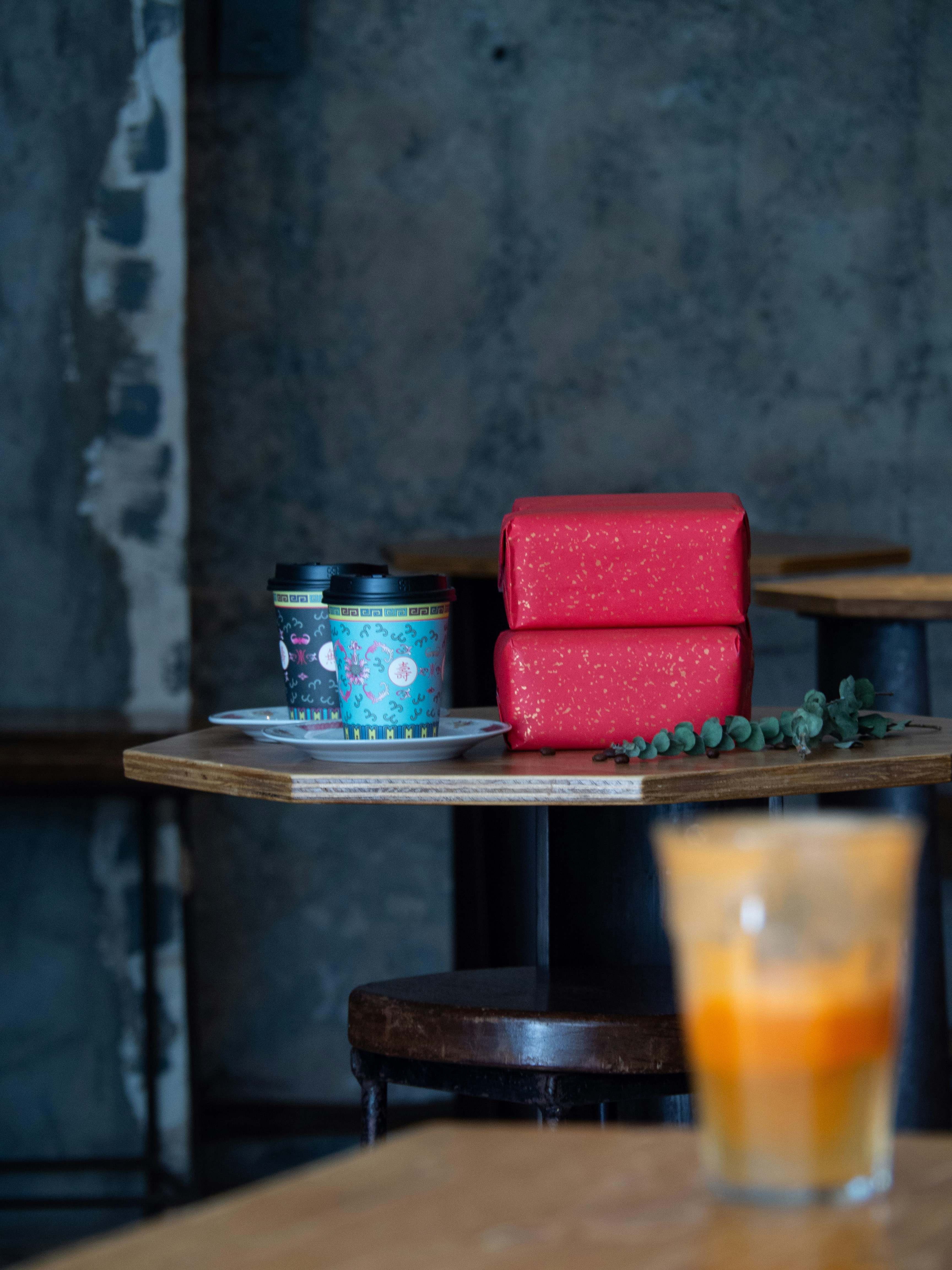 Cești de cafea și cutii cadou roșii pe o masă de lemn
