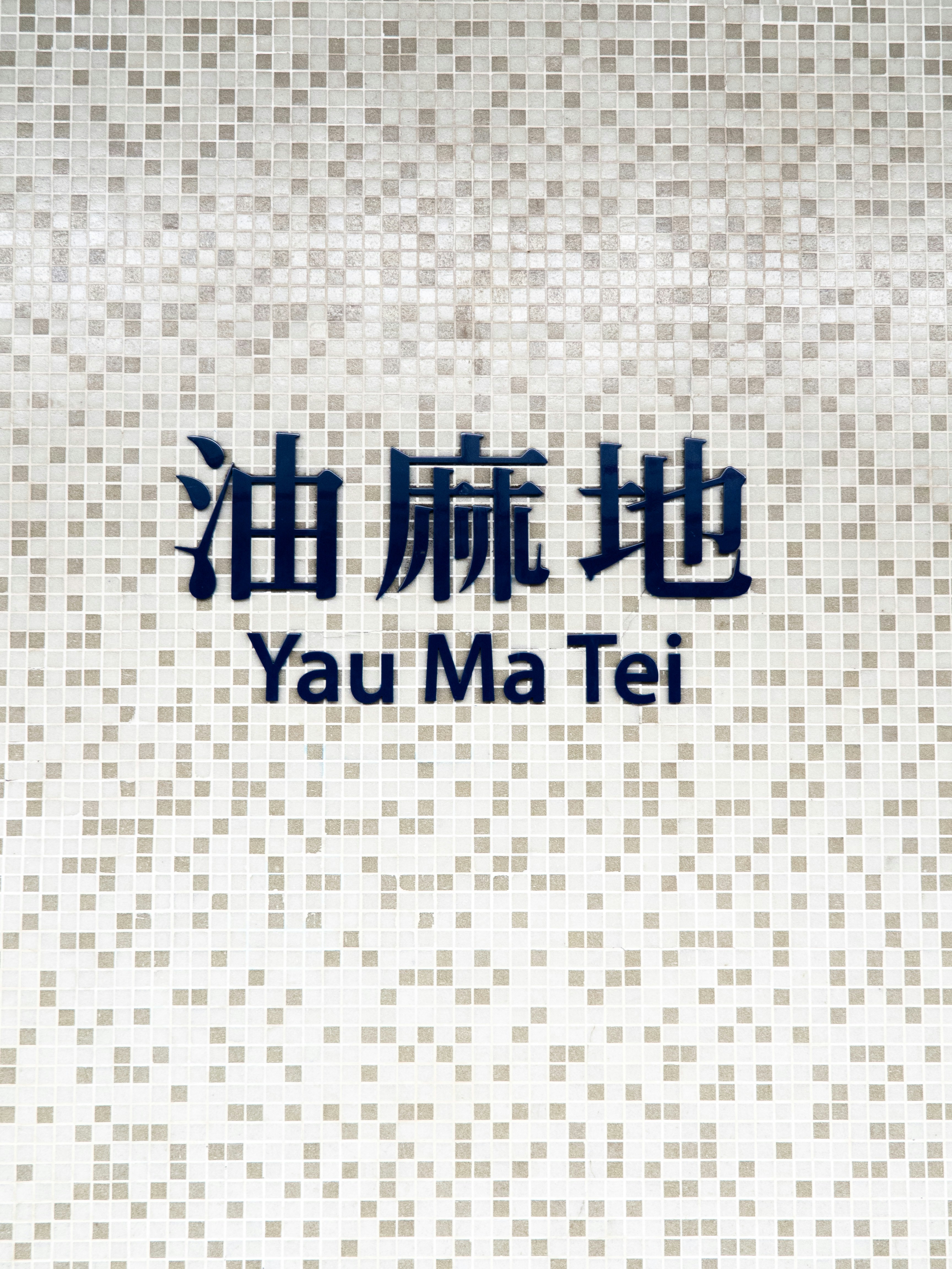 香港の白いタイルの壁に書かれた「油麻地」と書かれた看板