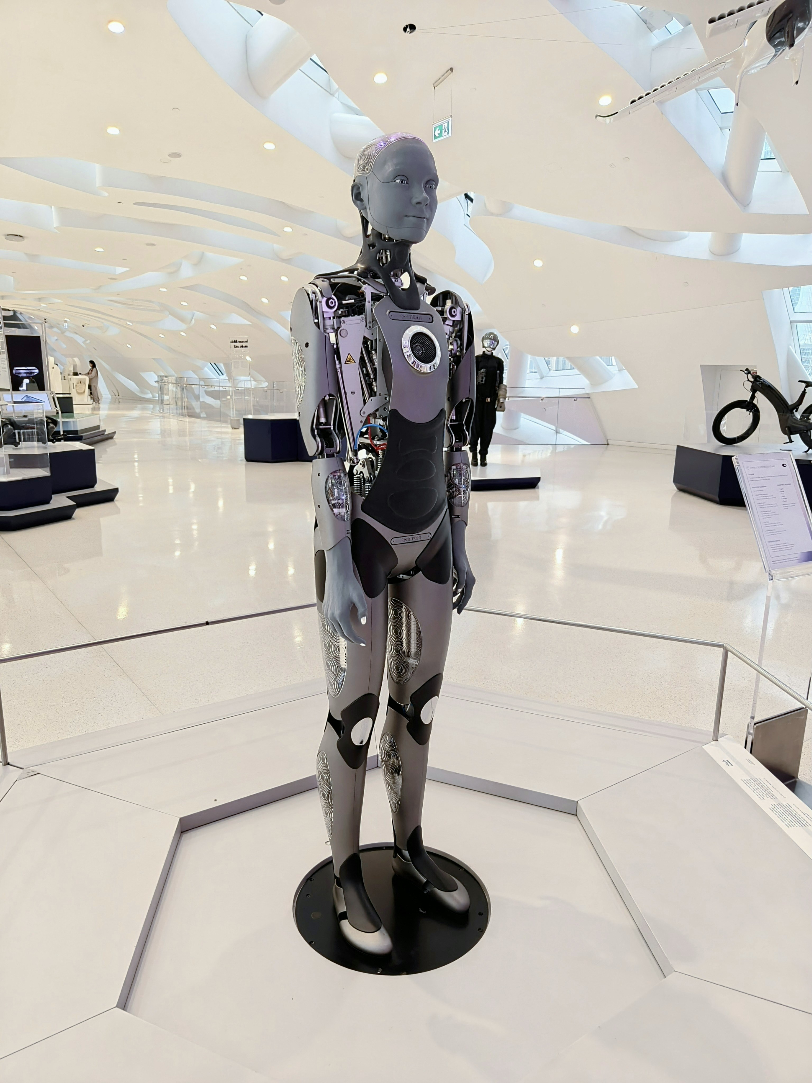 Un robot humanoïde aux articulations mécaniques exposées dans une galerie de musée moderne et lumineuse