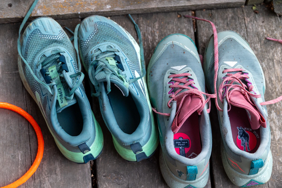 Zwei Paar Laufschuhe nebeneinander auf einer Holzterrasse