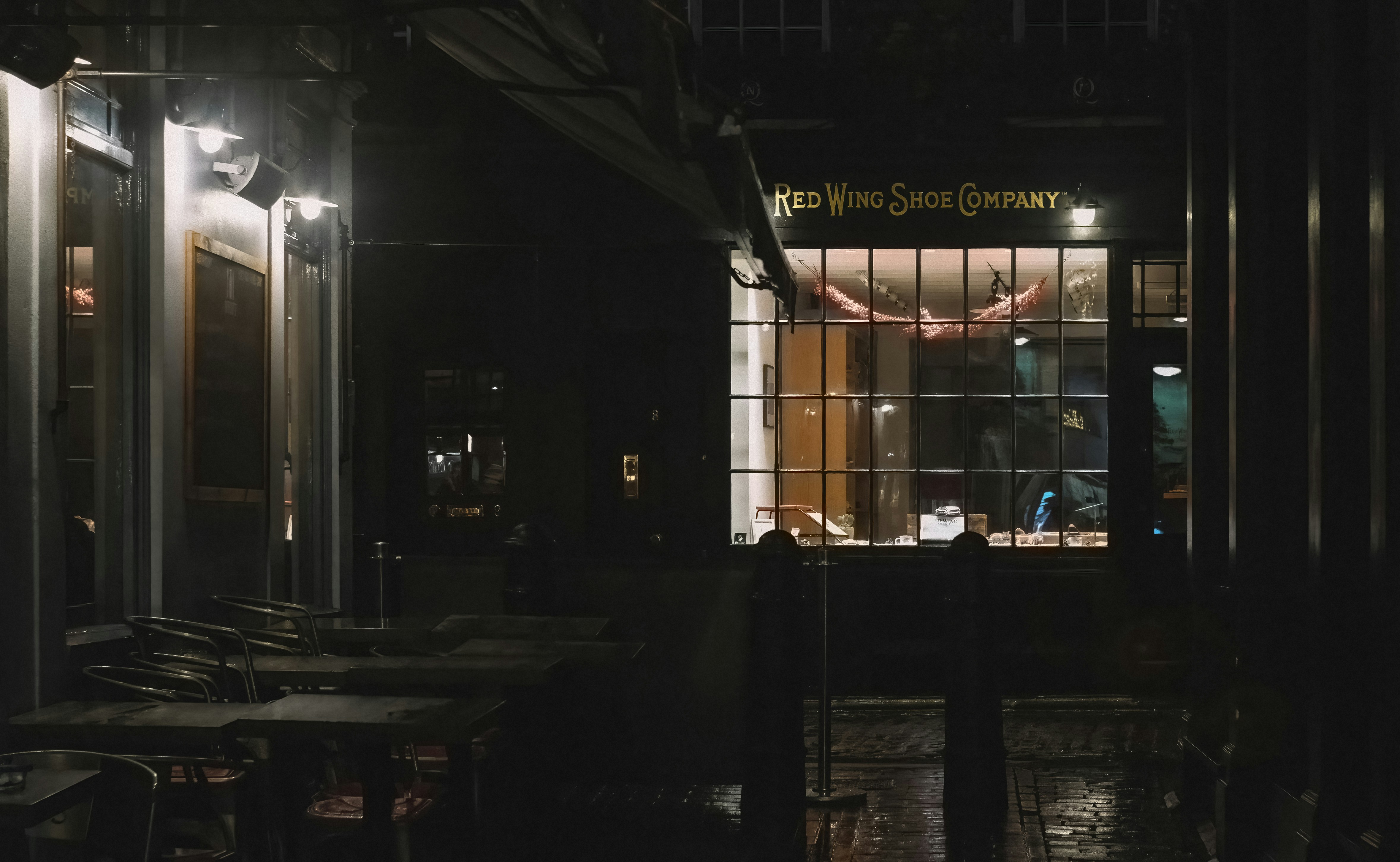 A storefront with a sign reading "Red Wing Shoe Company" at night.