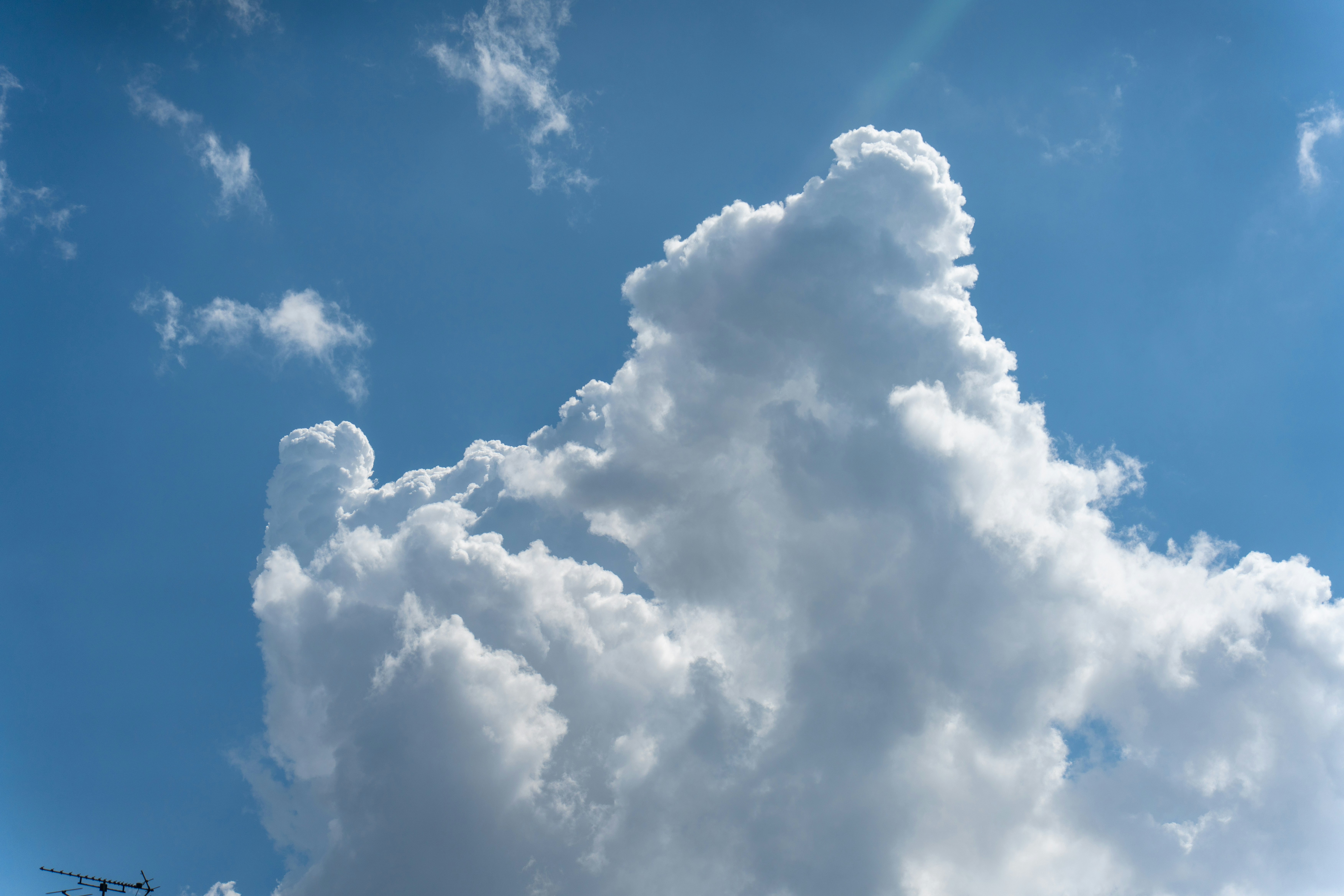 A large white cumulus cloud against a bright blue sky.