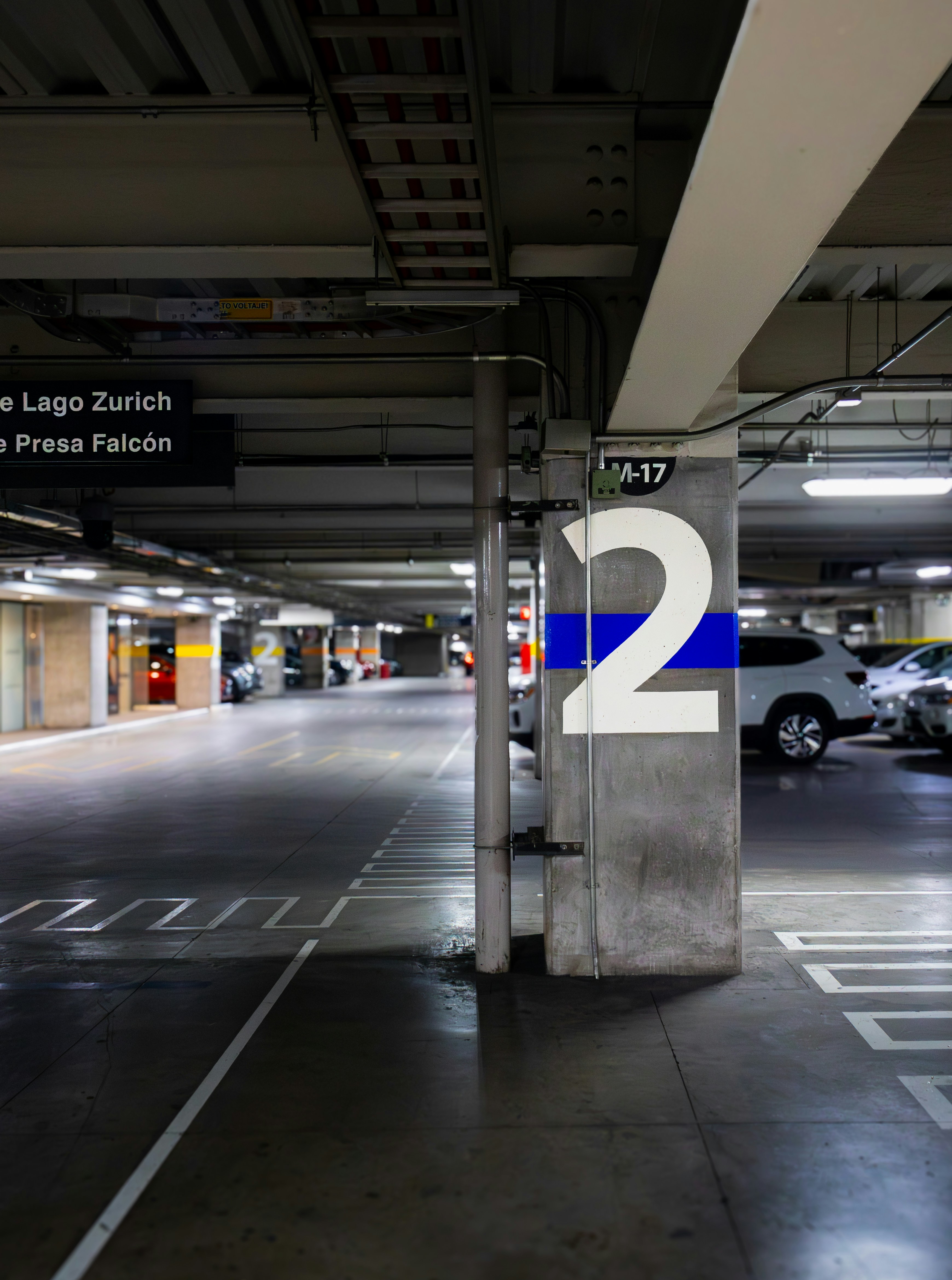 A concrete pillar marked with a large number two in an underground parking garage