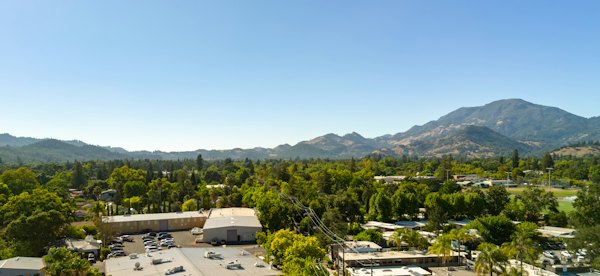 An aerial view of a town with green trees and distant mountains — Napa Valley, United States