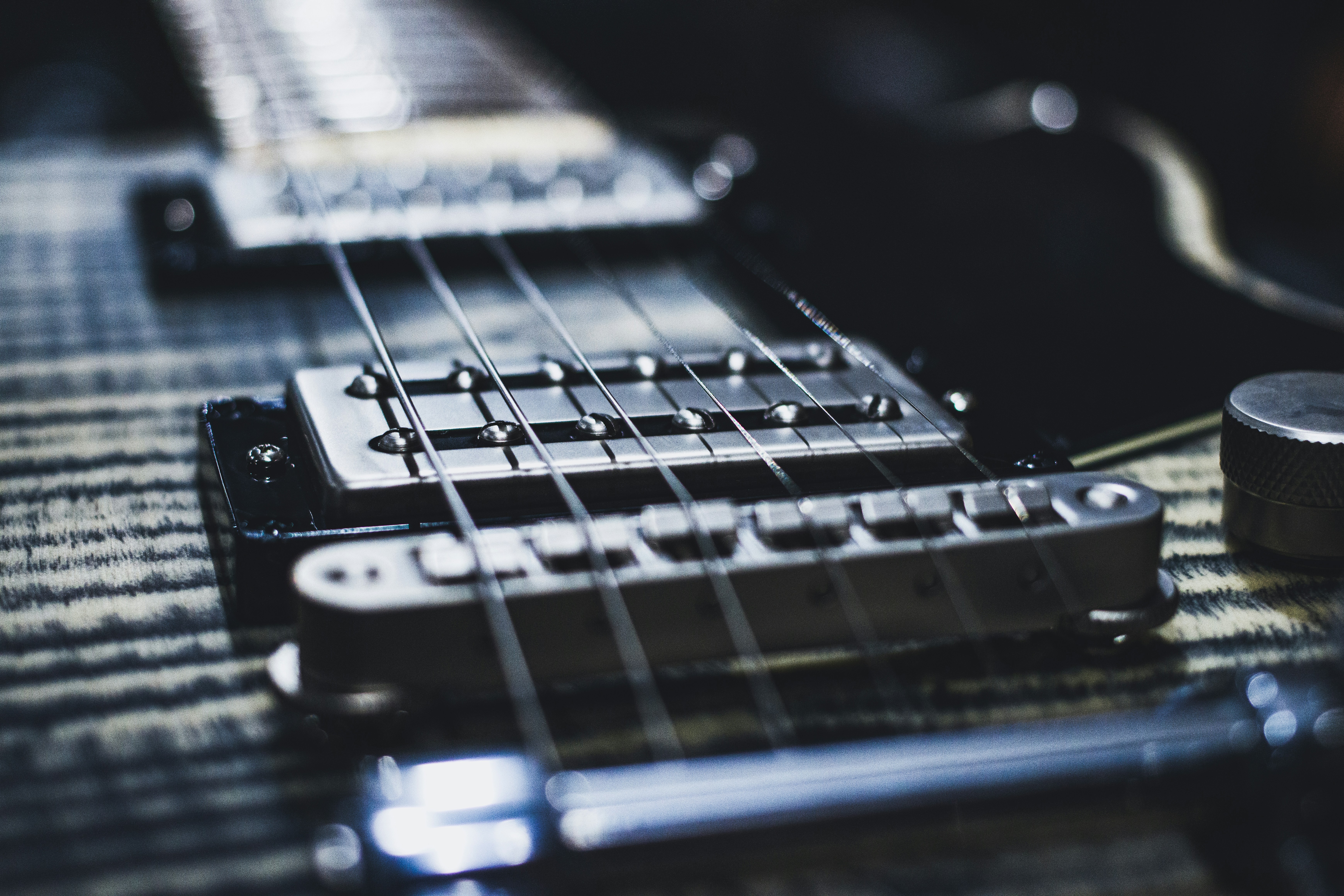 Close-up of electric guitar pickups and strings with a shallow depth of field