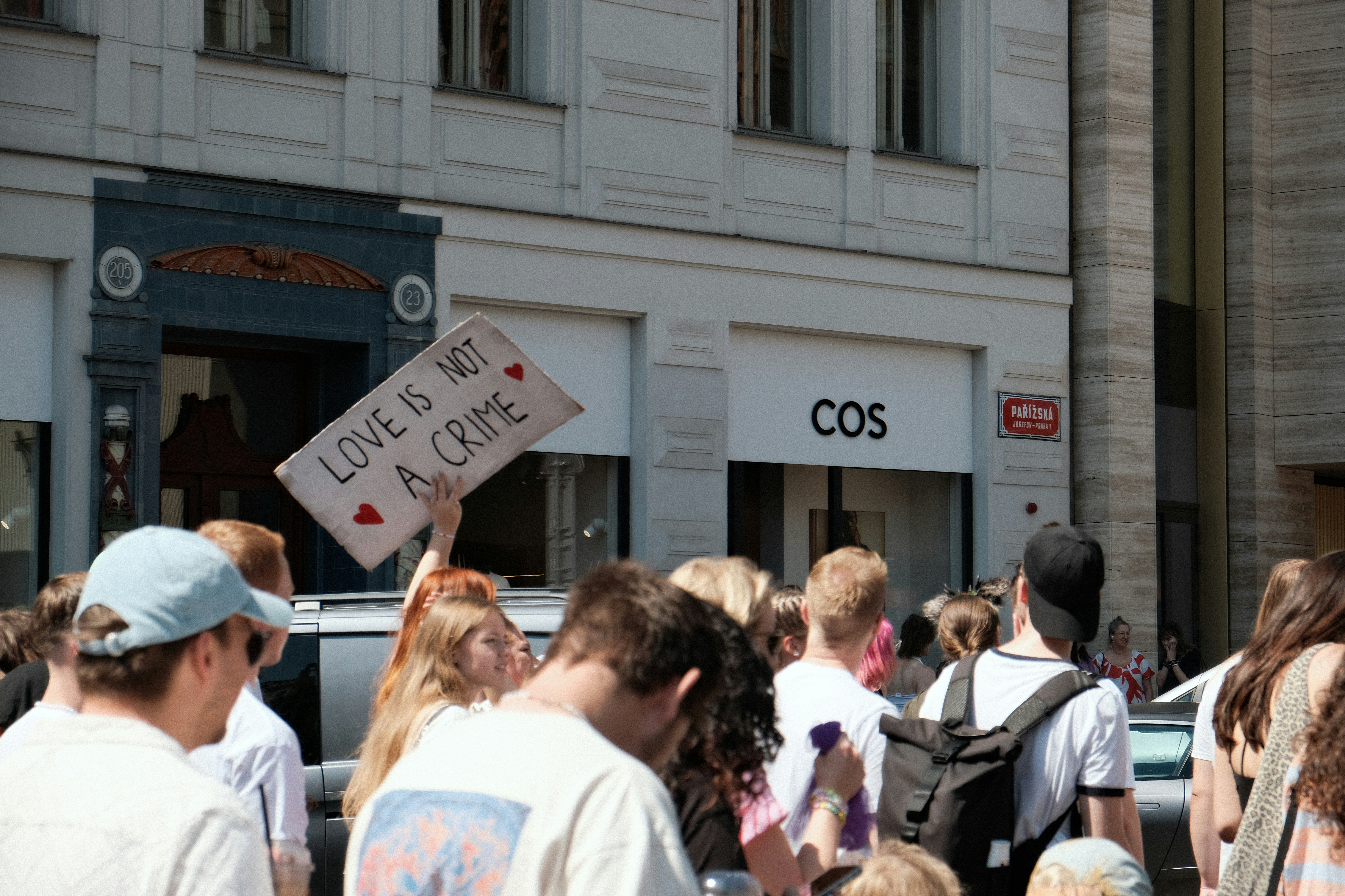 Eine Menschenmenge hält ein Schild mit der Aufschrift "LIEBE IST KEIN VERBRECHEN".
