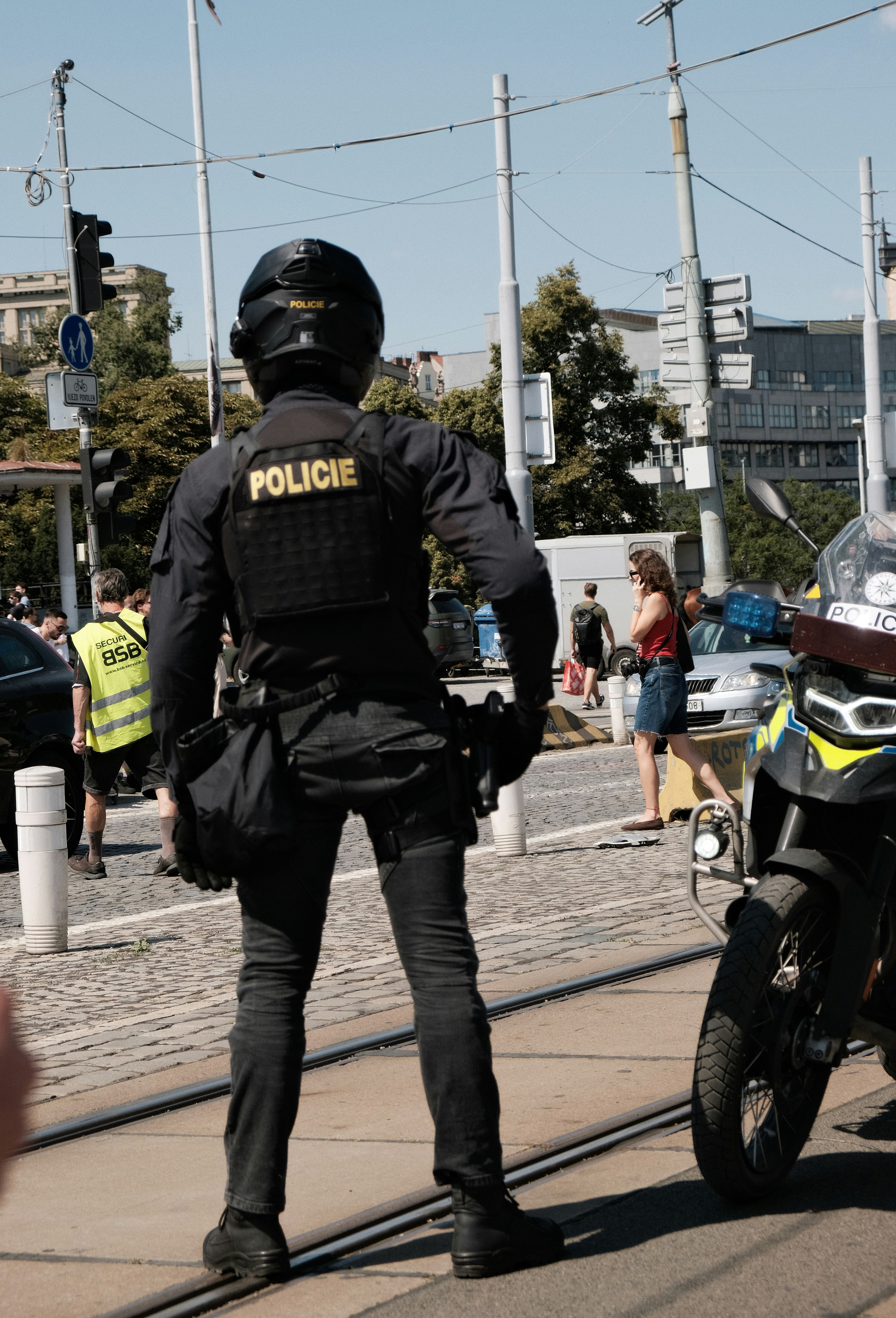 Ein Polizist in taktischer Ausrüstung steht auf einer Stadtstraße in der Nähe eines Motorrads.