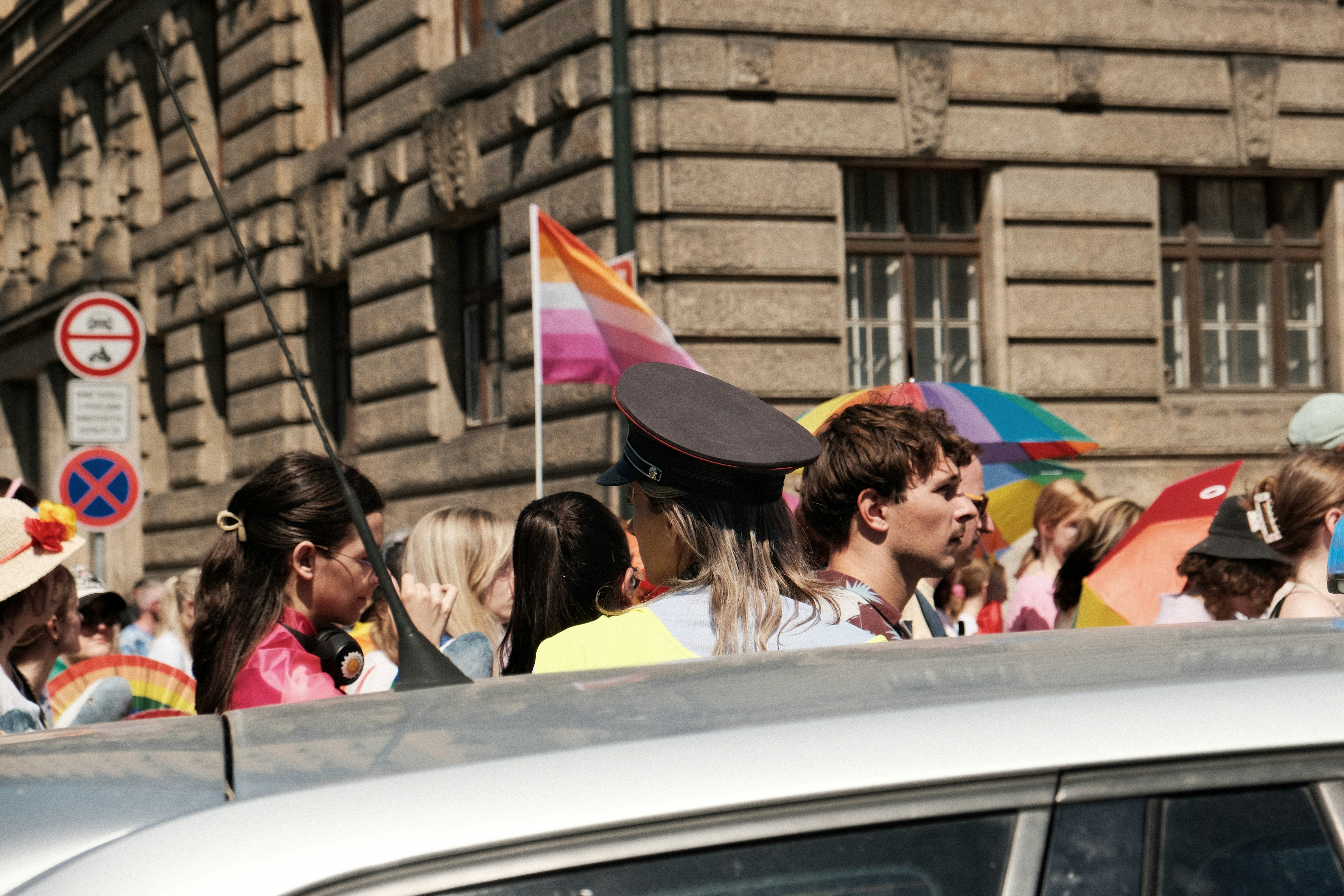 Eine Person mit Spitzmütze in einer Menschenmenge bei einer Pride-Parade.